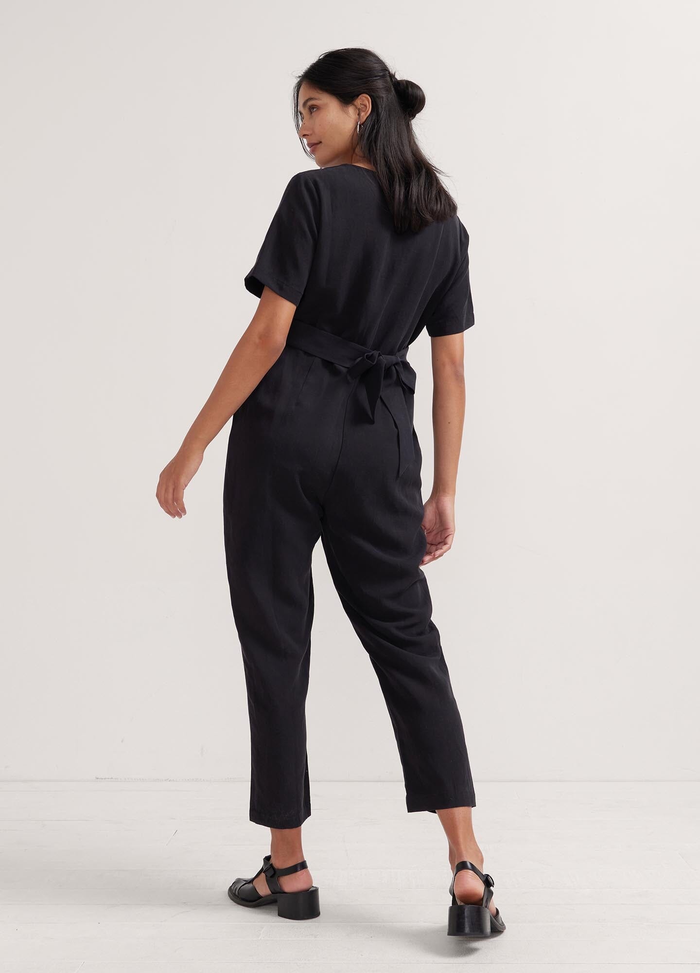 The Noelle Jumpsuit - Black short-sleeve maternity jumpsuit with button front, tailored fit for nursing and postpartum comfort.