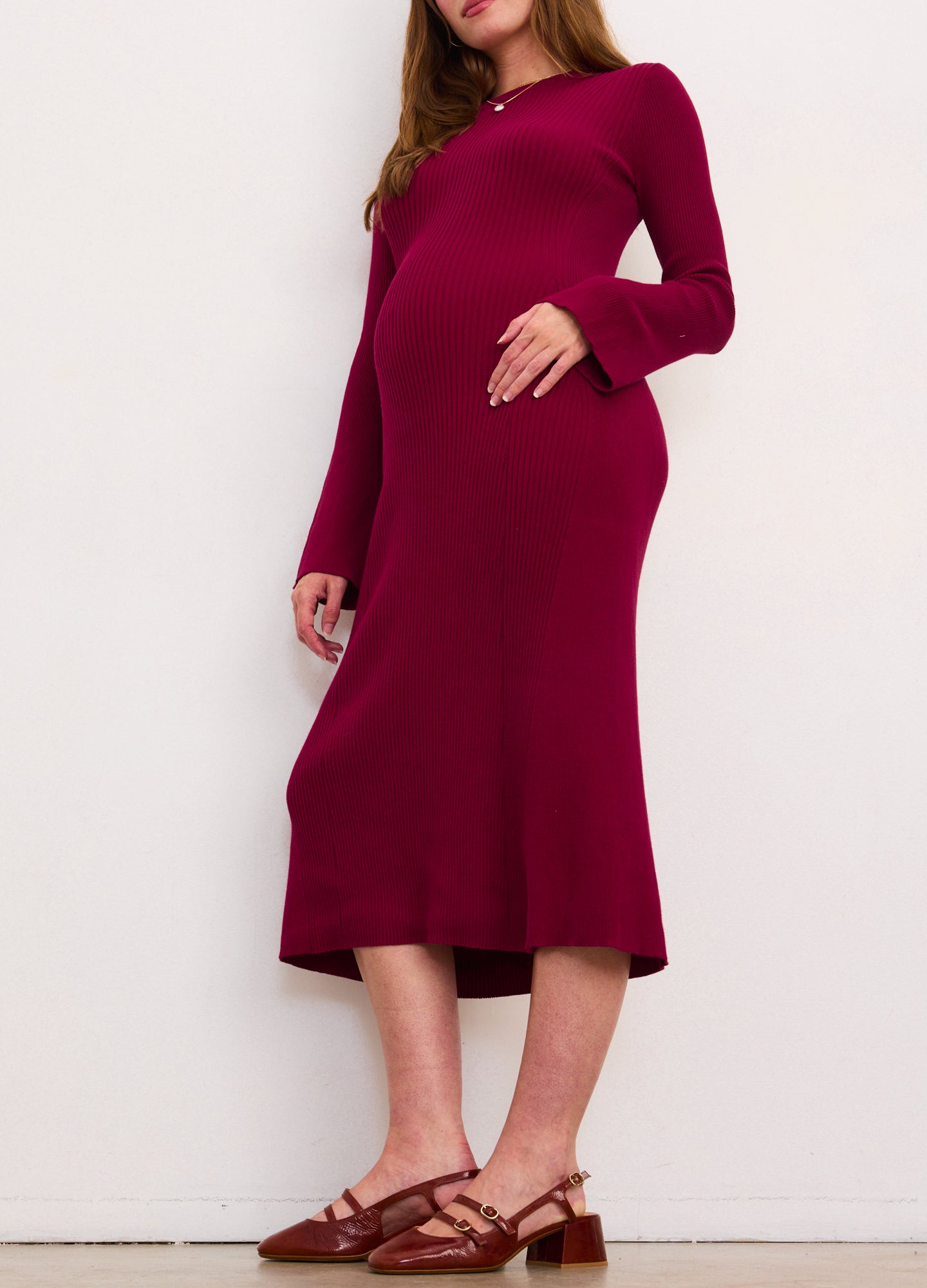 Burgundy ribbed midi dress with long sleeves and flared cuffs, designed for maternity fit.
