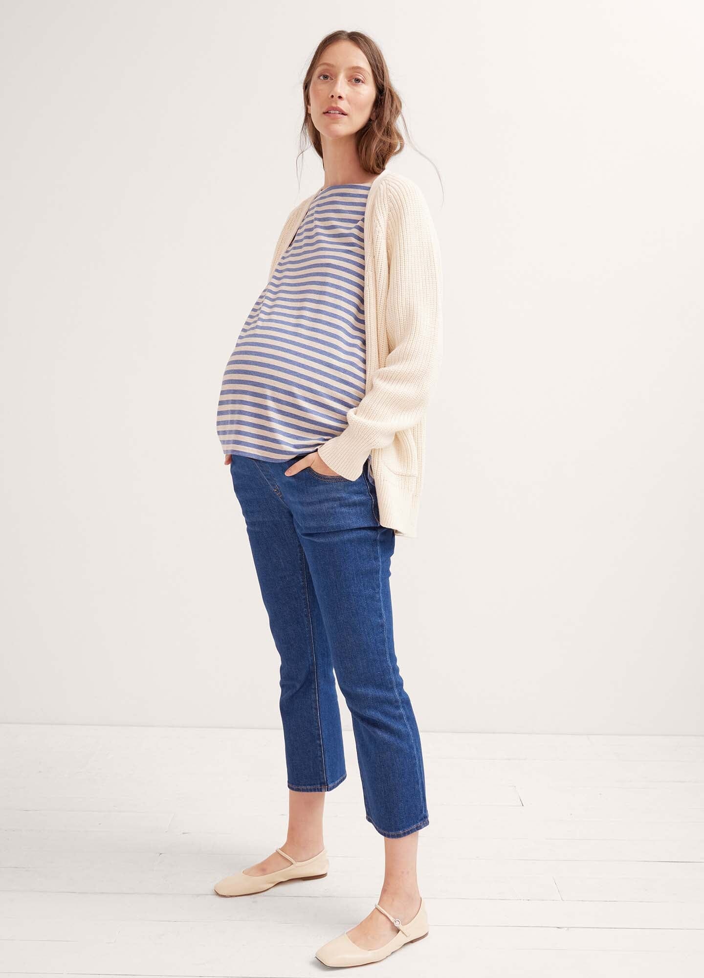 Pregnant woman wearing true blue cropped maternity jeans with over-the-bump panel and casual striped top.