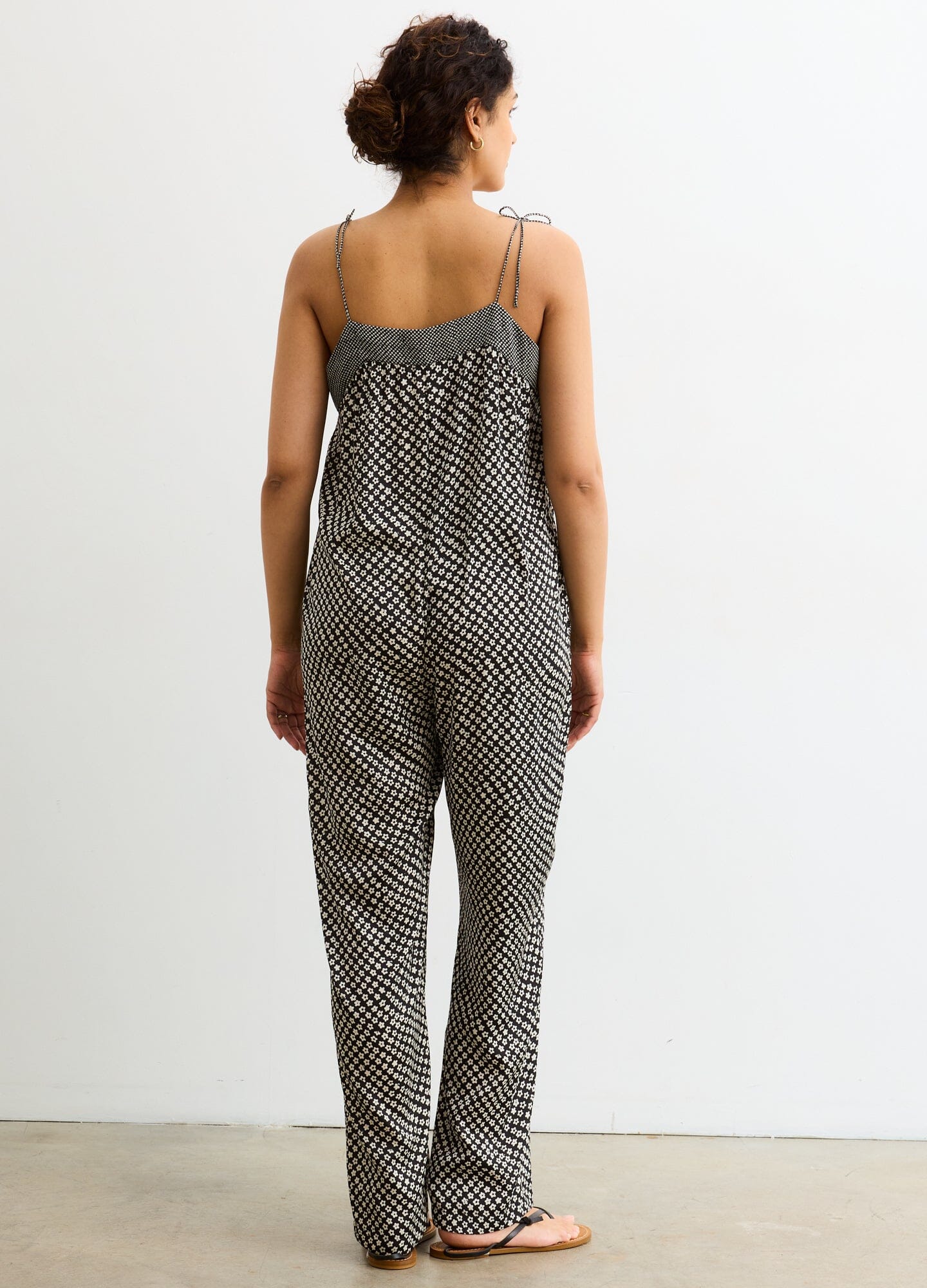 The Portia Jumpsuit - Black and white checkered maternity jumpsuit with adjustable straps and side ruching for pregnancy and nursing.