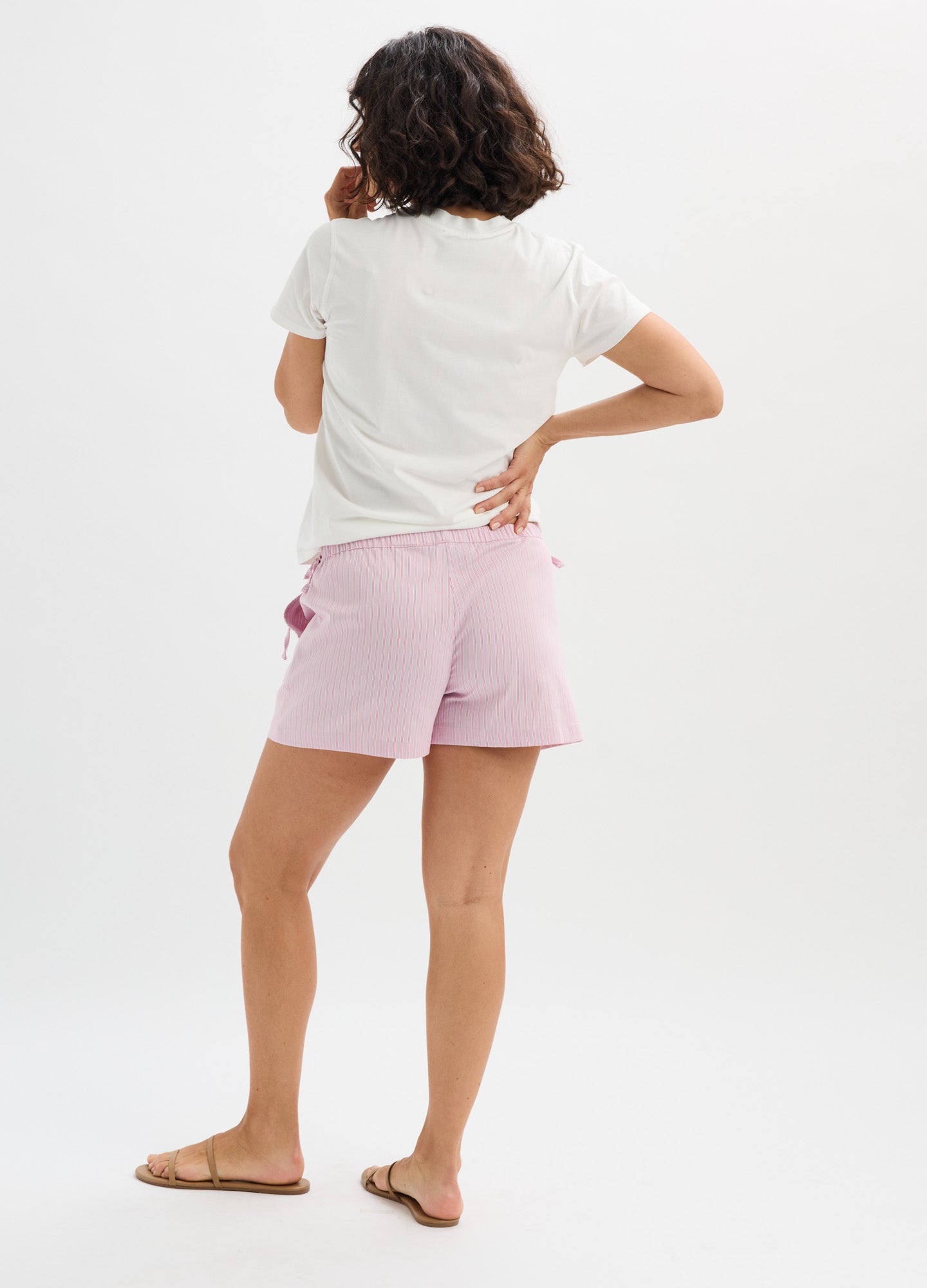 Light pink maternity shorts with side tie detail, soft fabric, relaxed fit, mid-thigh length.