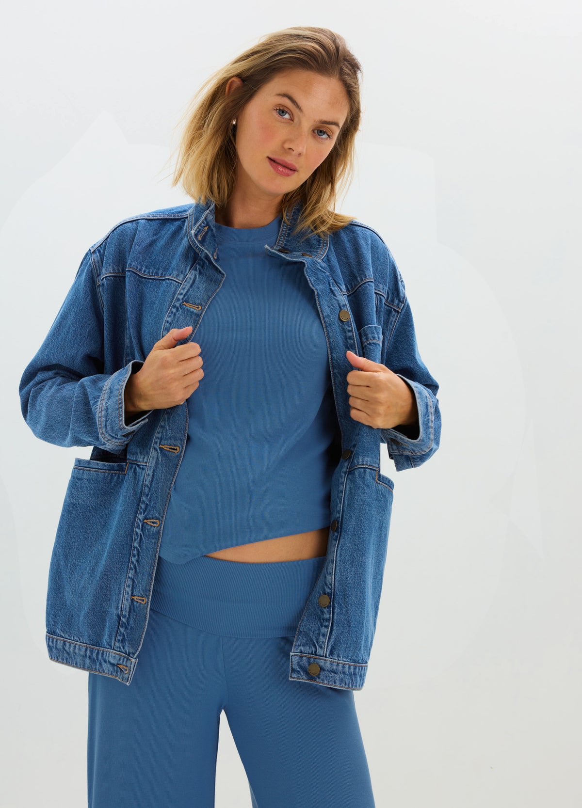 Blue ribbed maternity tee with long sleeves, paired with an oversized denim jacket, styled for a casual look.