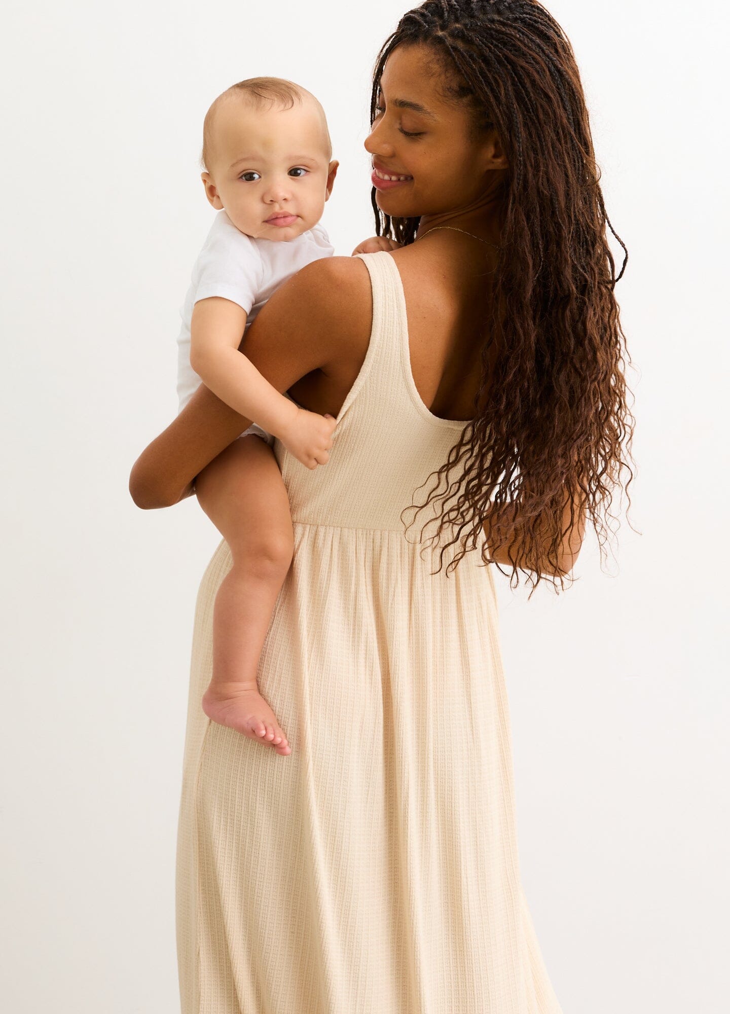 The Silky Ribbed Pointelle Nursing Dress - Sand-colored sleeveless midi dress with ribbed pointelle texture, designed for maternity, nursing, and postpartum.