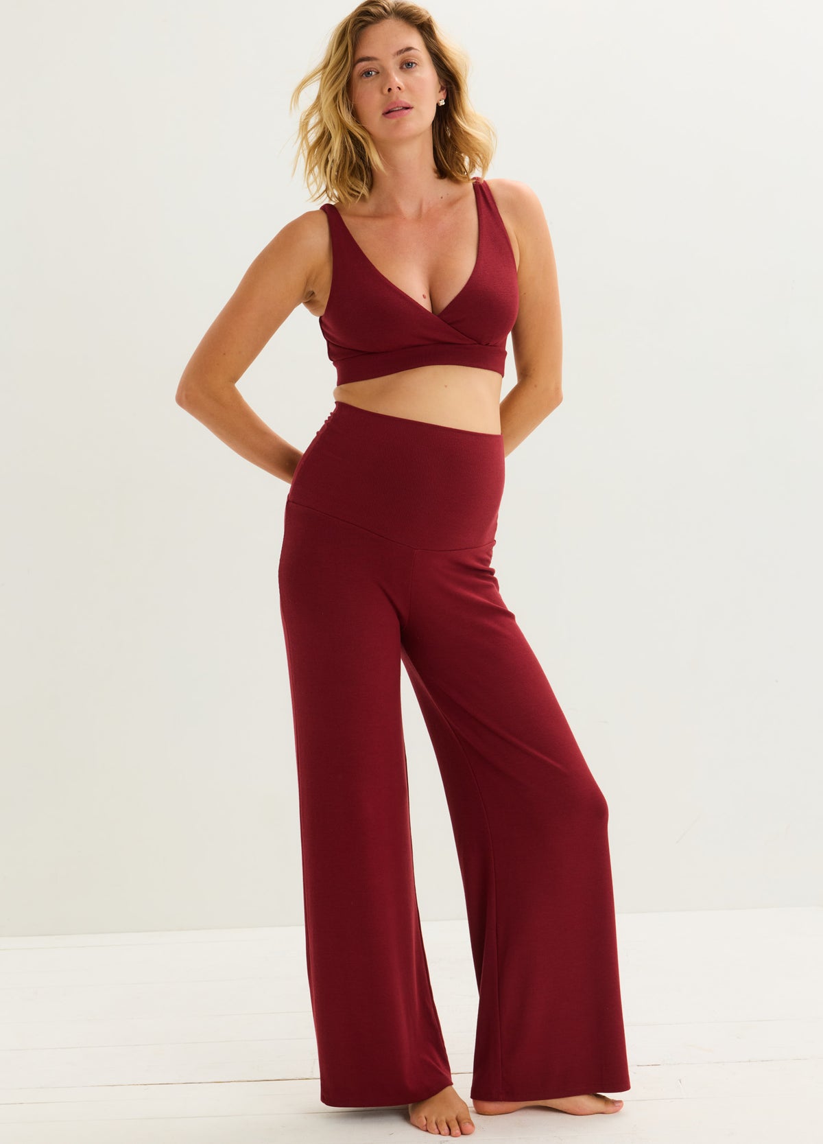 Burgundy ribbed maternity pants with wide legs and a relaxed high waist designed for pregnant comfort.