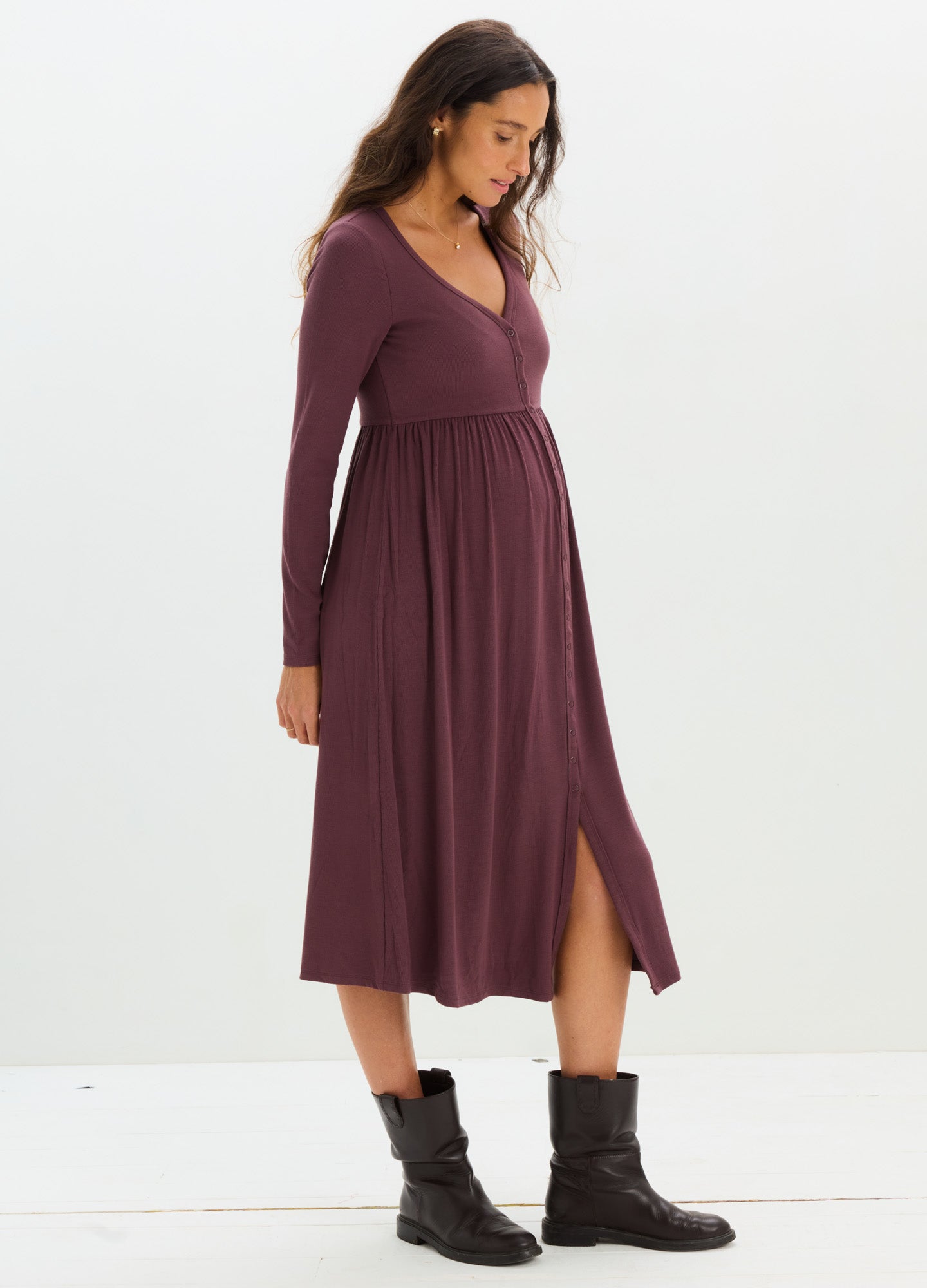 Plum ribbed long-sleeve maternity dress with V-neck and side slit, styled with black ankle boots.