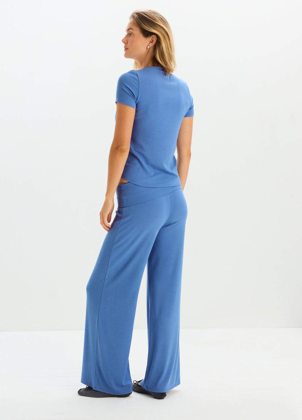 Blue ribbed relaxed maternity pants with wide legs and high waist, paired with a fitted blue short-sleeve top.