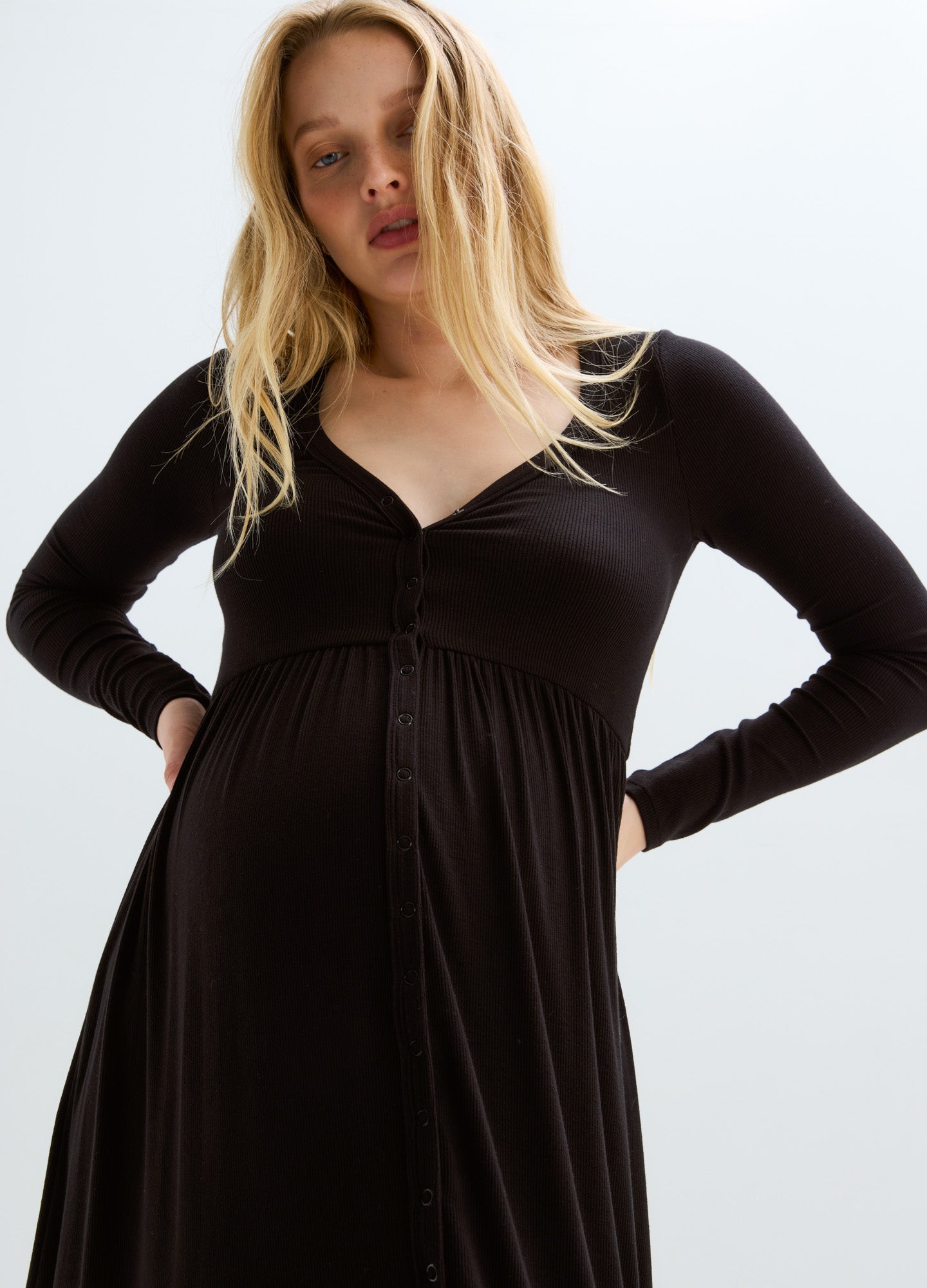 Black long-sleeve ribbed maternity dress with V-neck and gathered empire waist for nursing access.