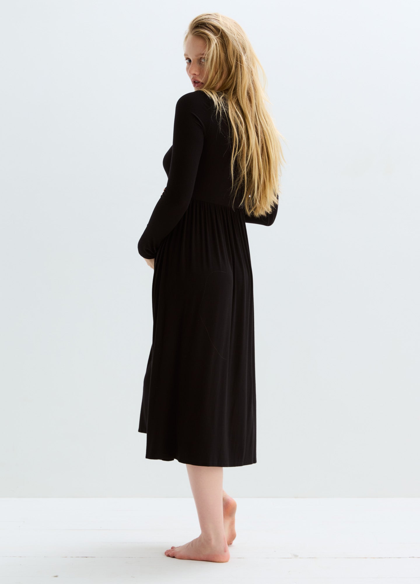 Black ribbed maternity nursing dress with long sleeves and midi length, soft stretchy fabric.
