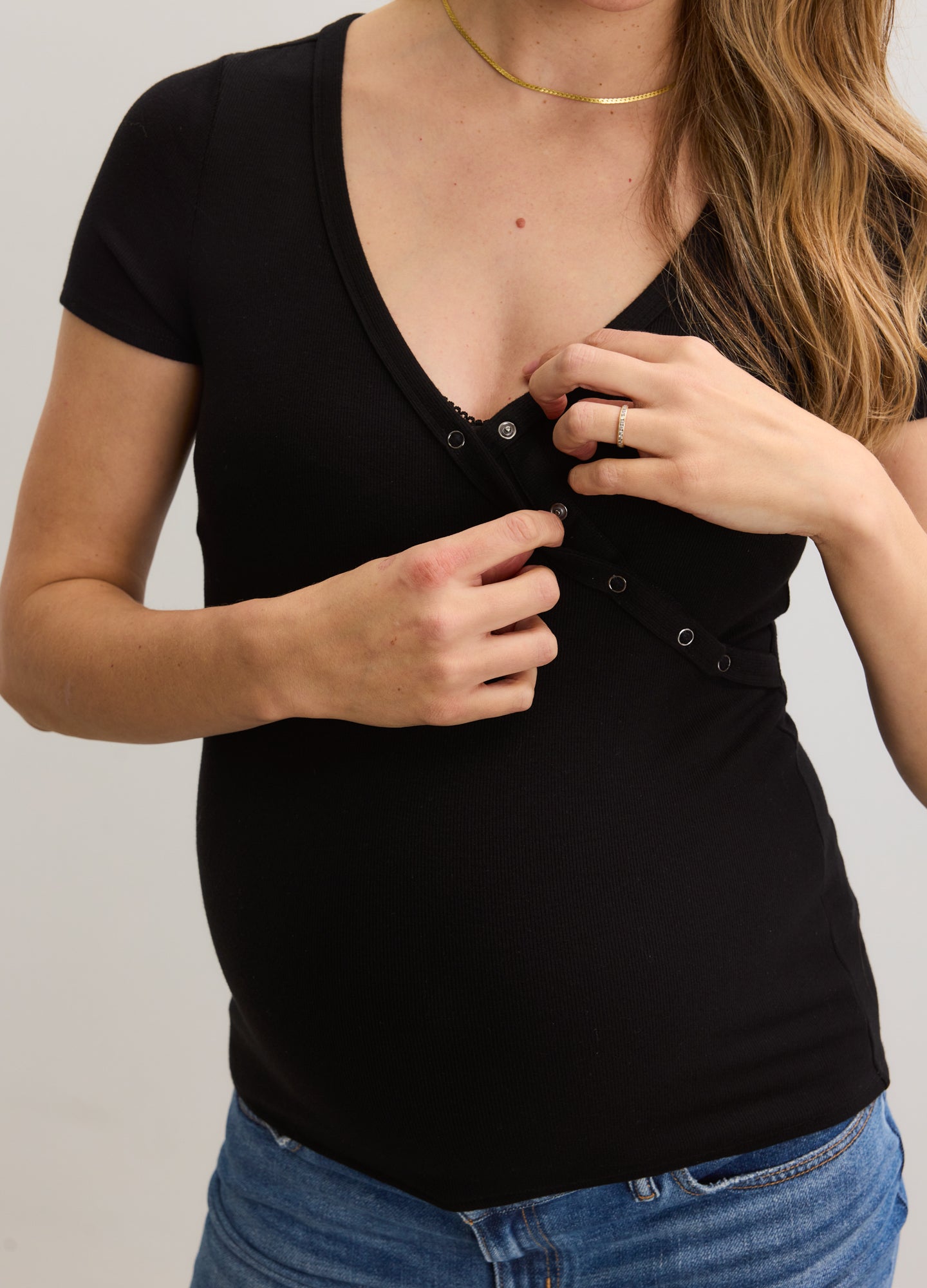 Black ribbed short-sleeve maternity tee with front button placket, fitted through the baby bump.