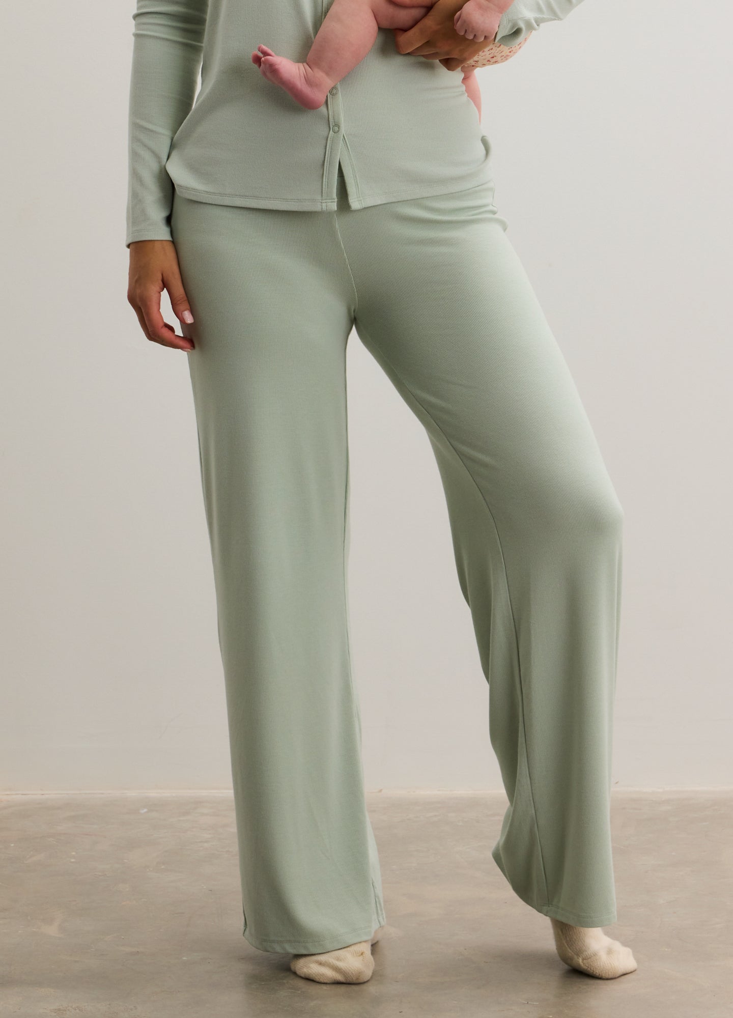 Light sage green ribbed maternity pants with relaxed wide-leg fit and soft fabric.