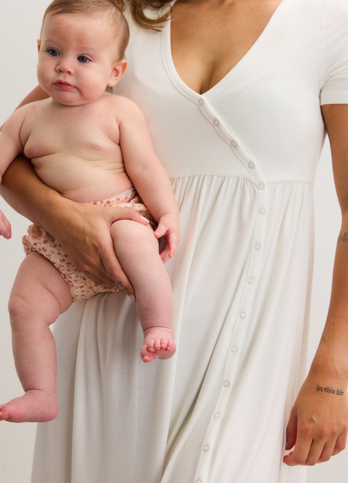 White ribbed short-sleeve nursing maxi dress with side seams and button details, designed for maternity.