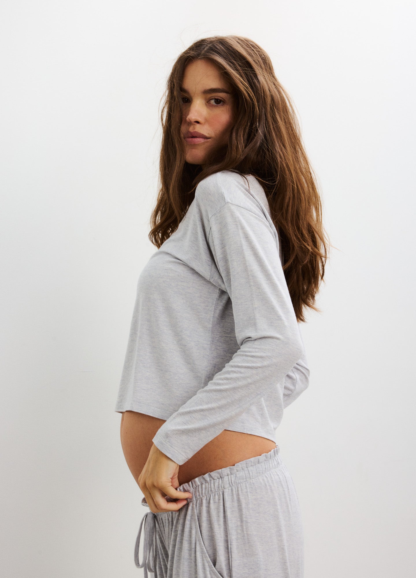 Light gray long sleeve maternity tee with soft fabric and relaxed fit, designed for pregnant figures.