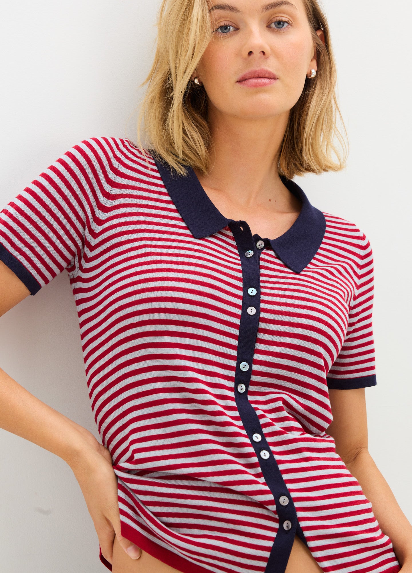 Red and white striped maternity shirt with navy collar and button placket, short sleeves, fitted to pregnant belly.