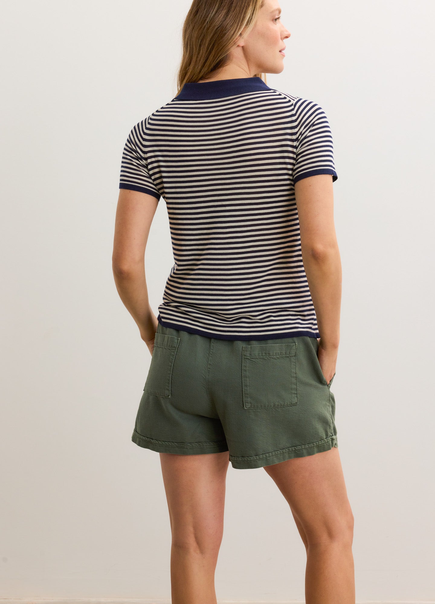 Navy and white striped maternity shirt with short sleeves and navy trim, worn with olive green shorts.