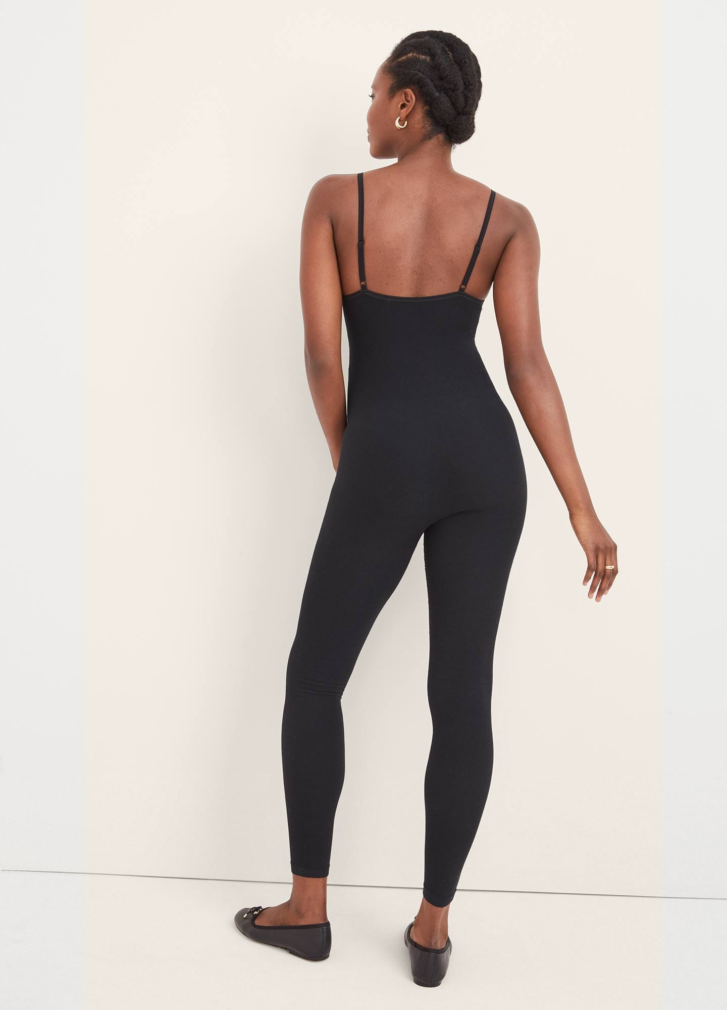 The Body Rib Unitard - Black ribbed maternity unitard with long sleeves and slim fit, designed for pregnancy, nursing, and postpartum comfort.