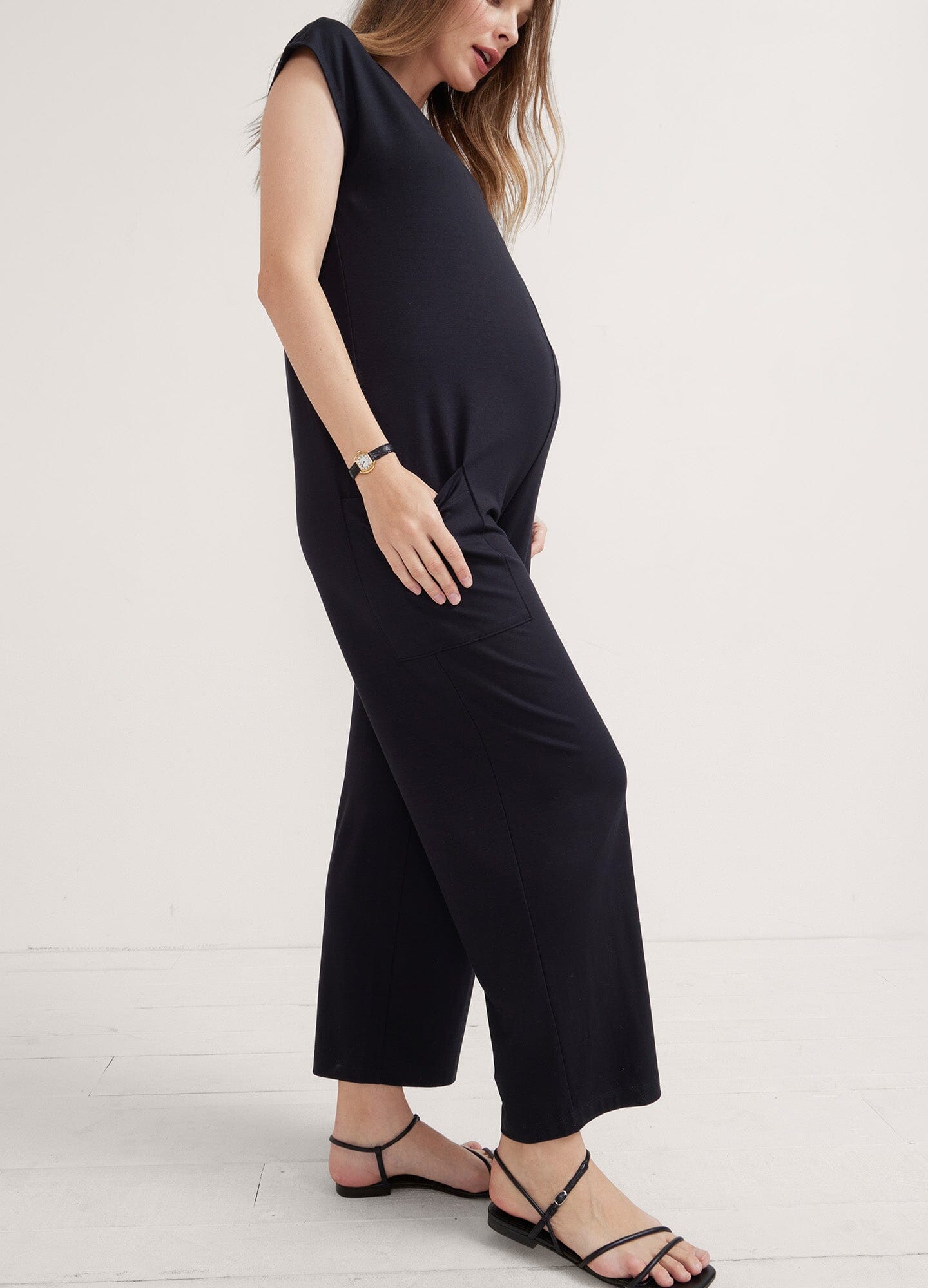 Black sleeveless maternity jumpsuit with wide legs and relaxed fit, styled for pregnant wear.