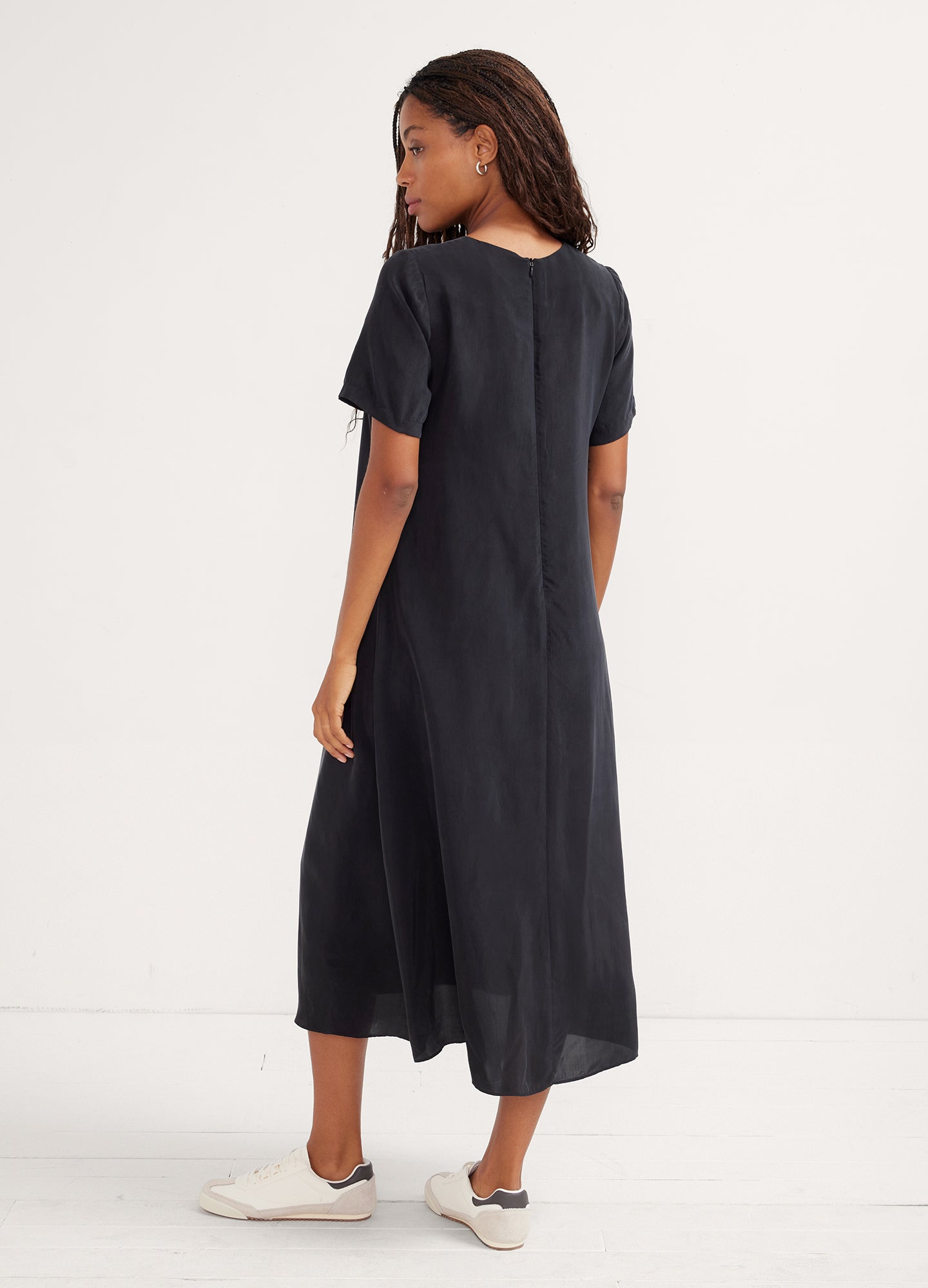 Black short-sleeve maternity dress with midi length and relaxed fit.