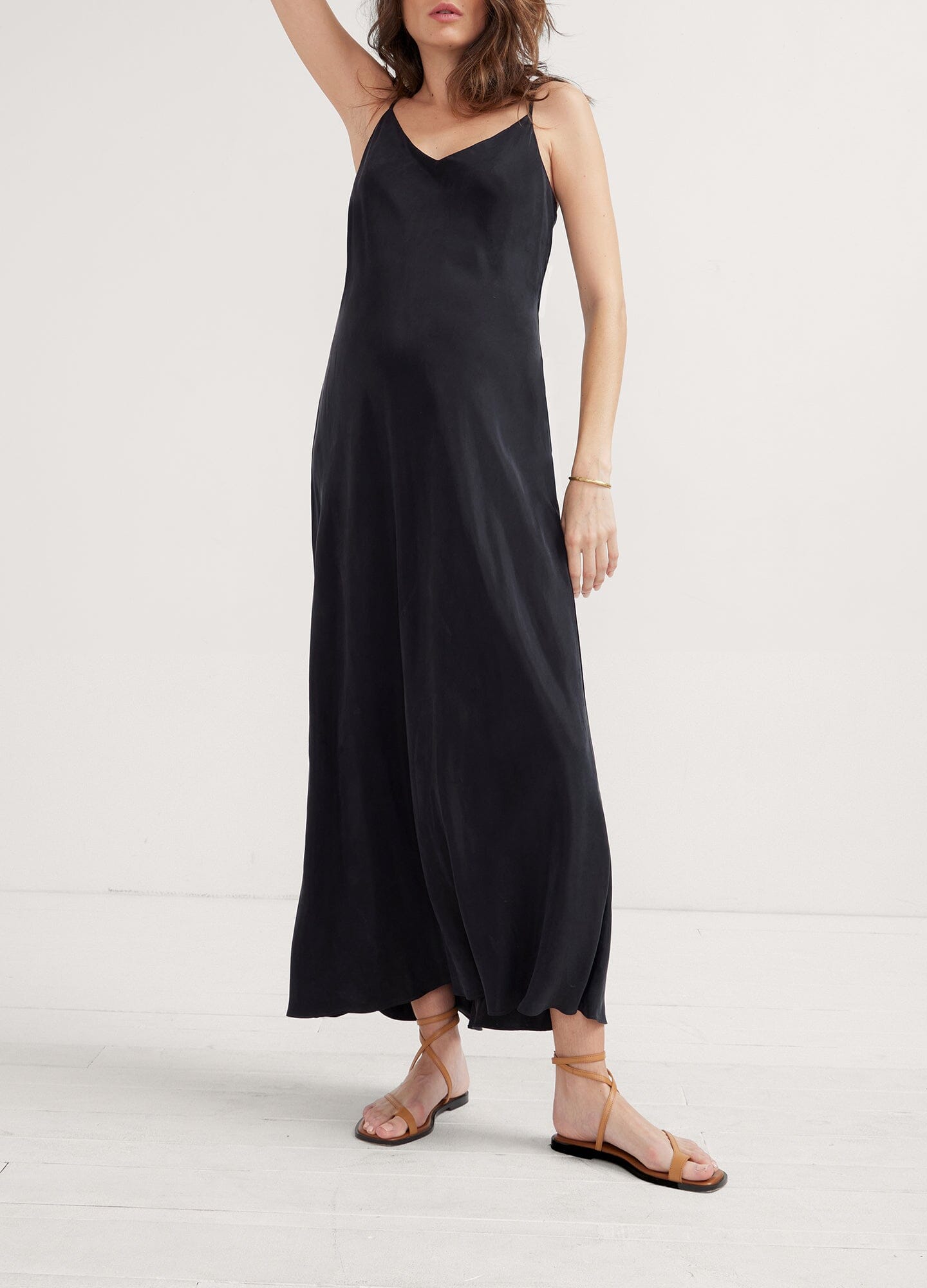 The Ricky Slip Dress - Black maternity slip dress with adjustable straps, designed for pregnancy, nursing, and postpartum, worn with casual ease.