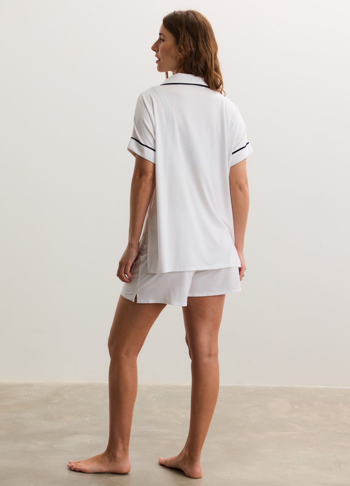White soft jersey short-sleeve maternity top and matching shorts with black piping trim.