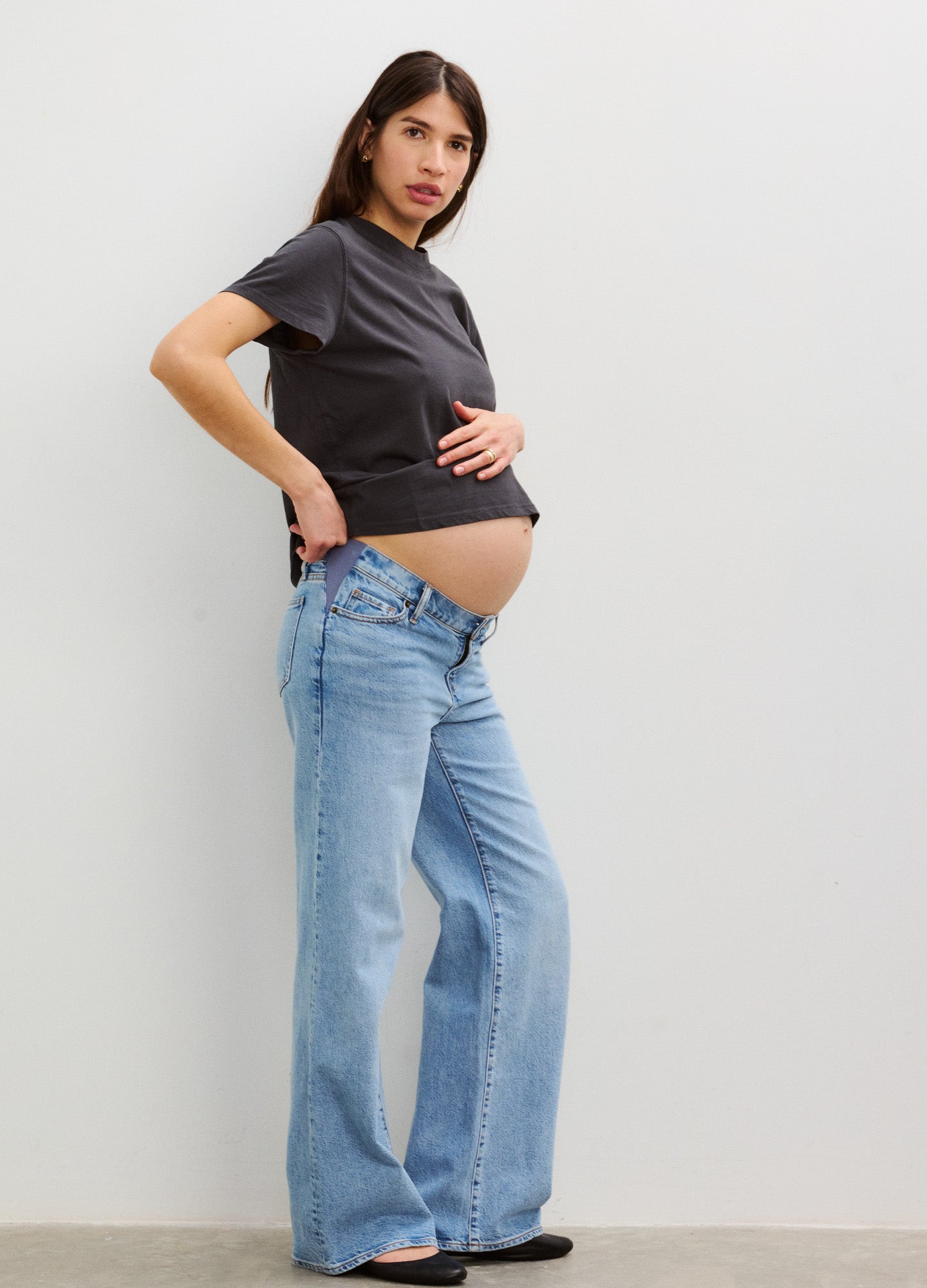 Black washed cotton maternity crew neck t-shirt paired with light blue wide-leg jeans.