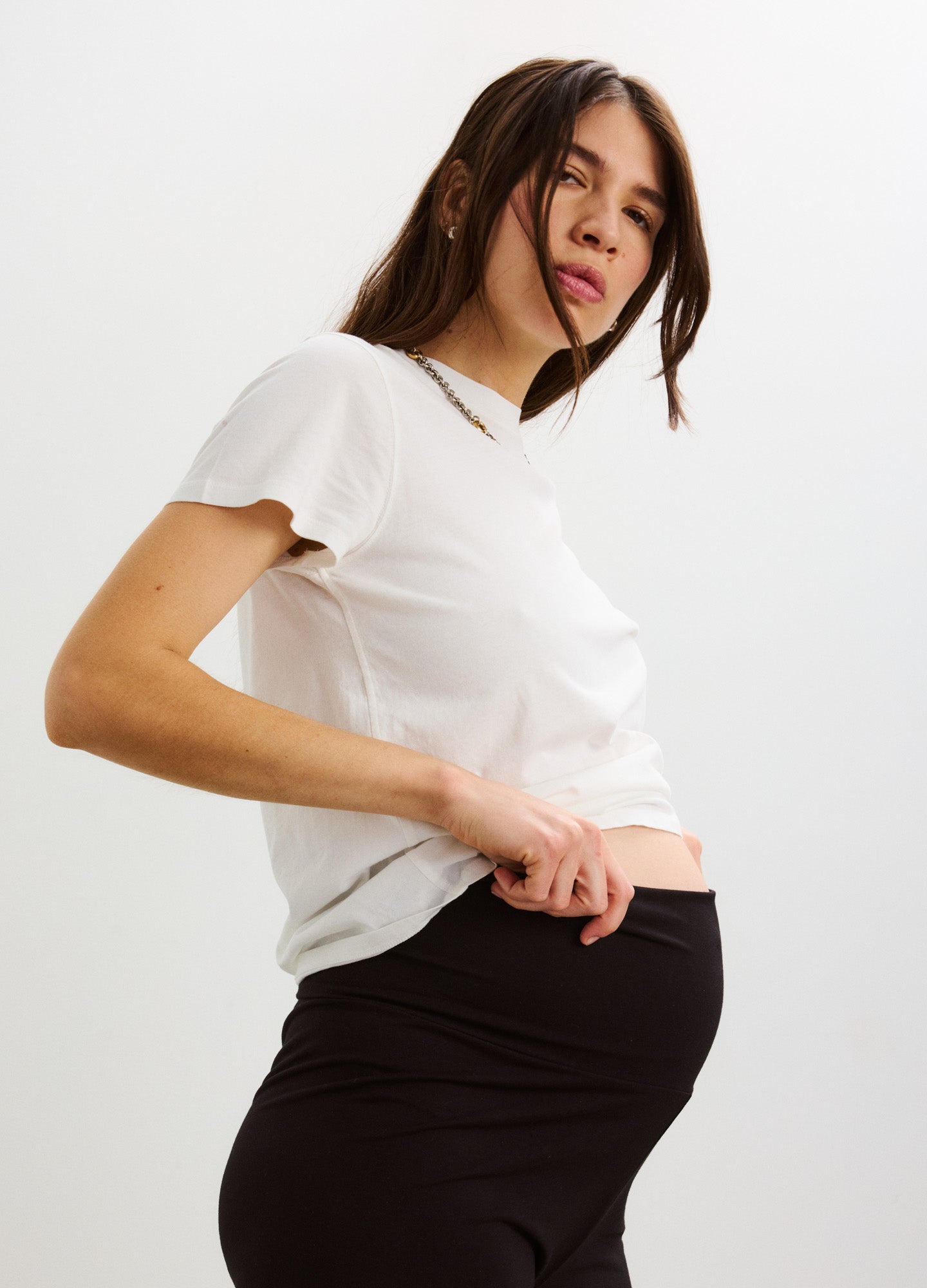 White washed cotton crew neck maternity t-shirt with short sleeves, fitted over pregnant belly.