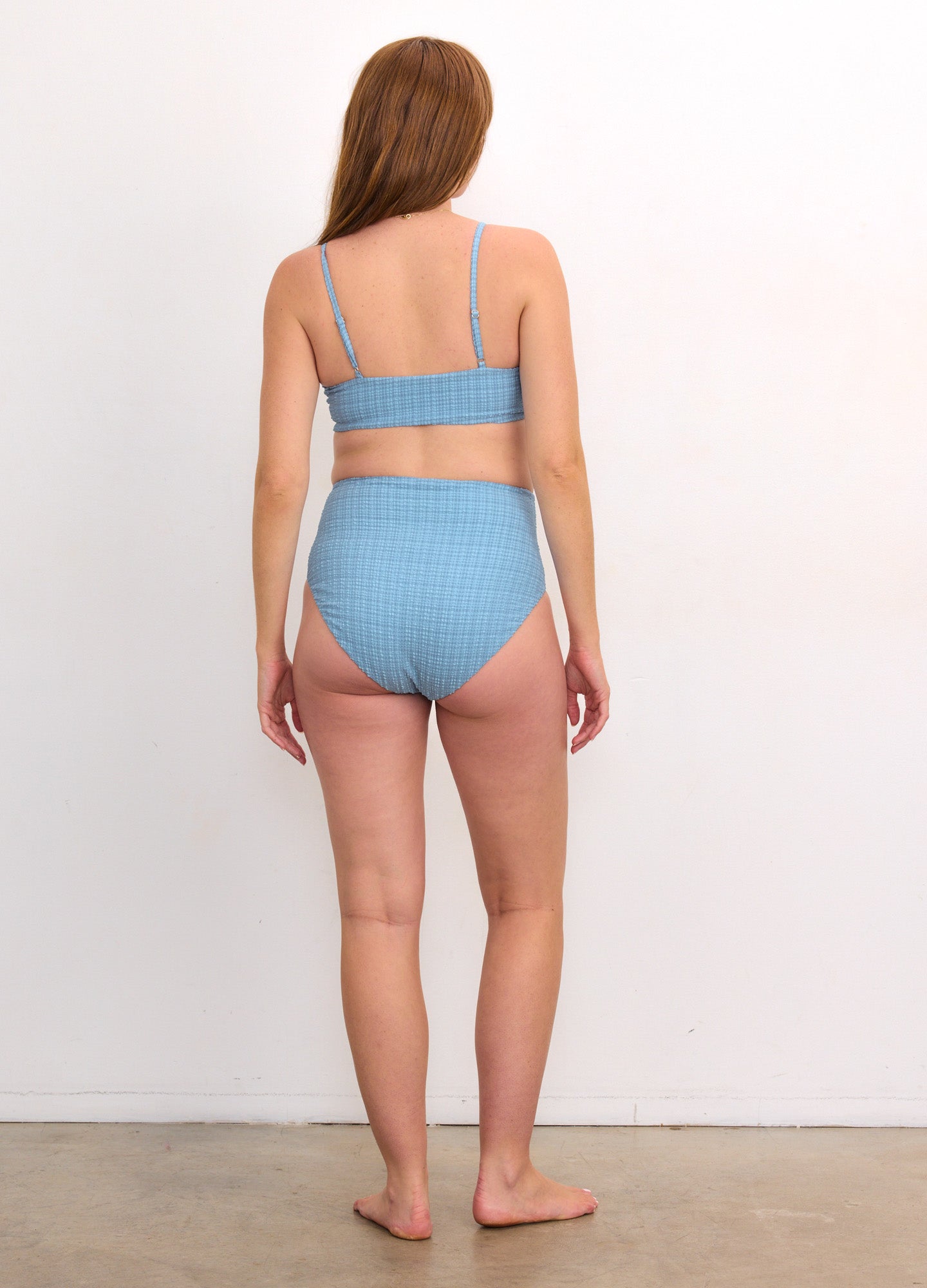 Light blue ribbed maternity bikini with adjustable straps and high-waisted bottom designed for pregnant women.
