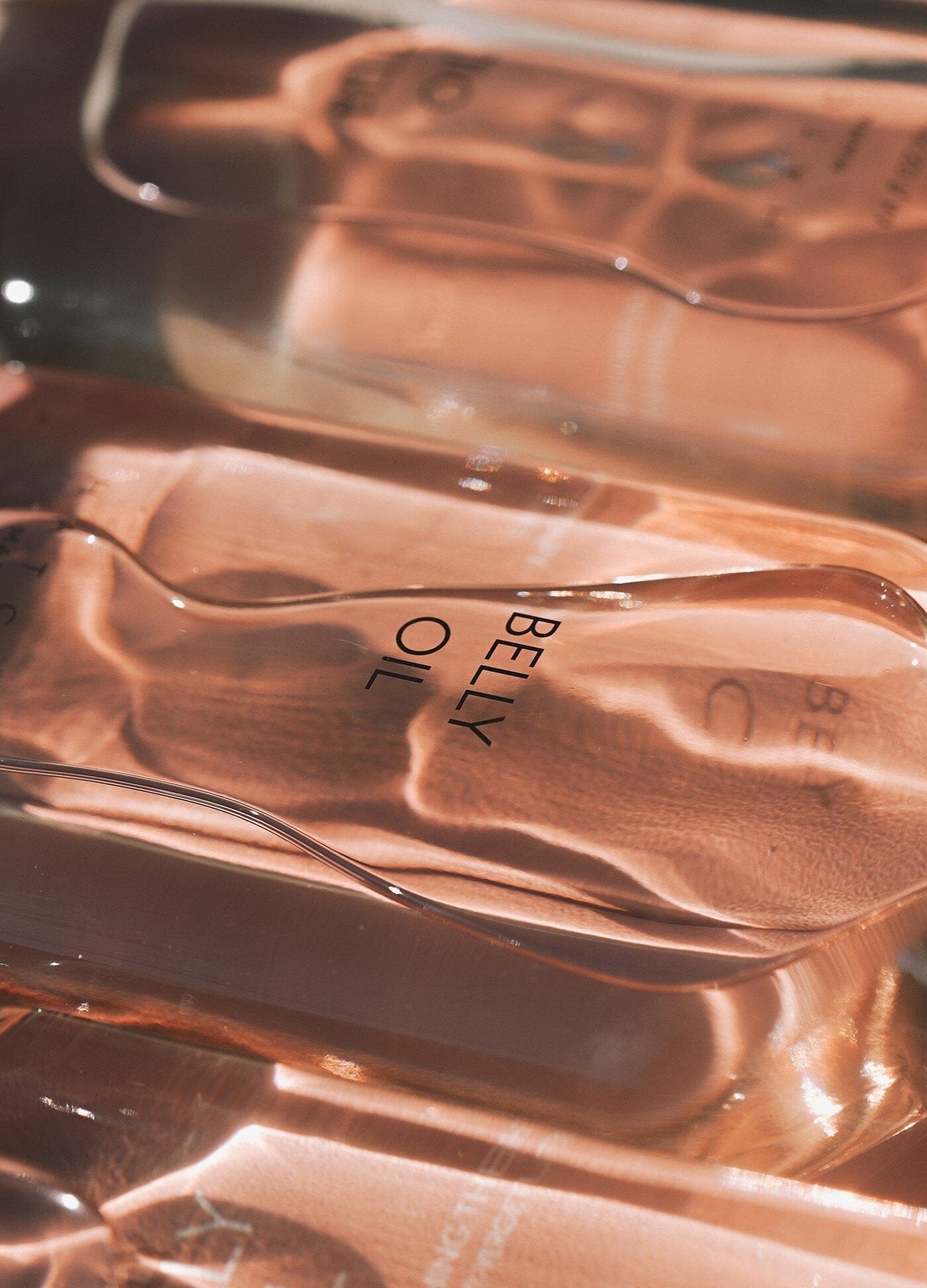 Belly Oil (Copy) - Clear glass bottle of maternity belly oil with soft pink liquid, designed for pregnancy, nursing, and postpartum care next.