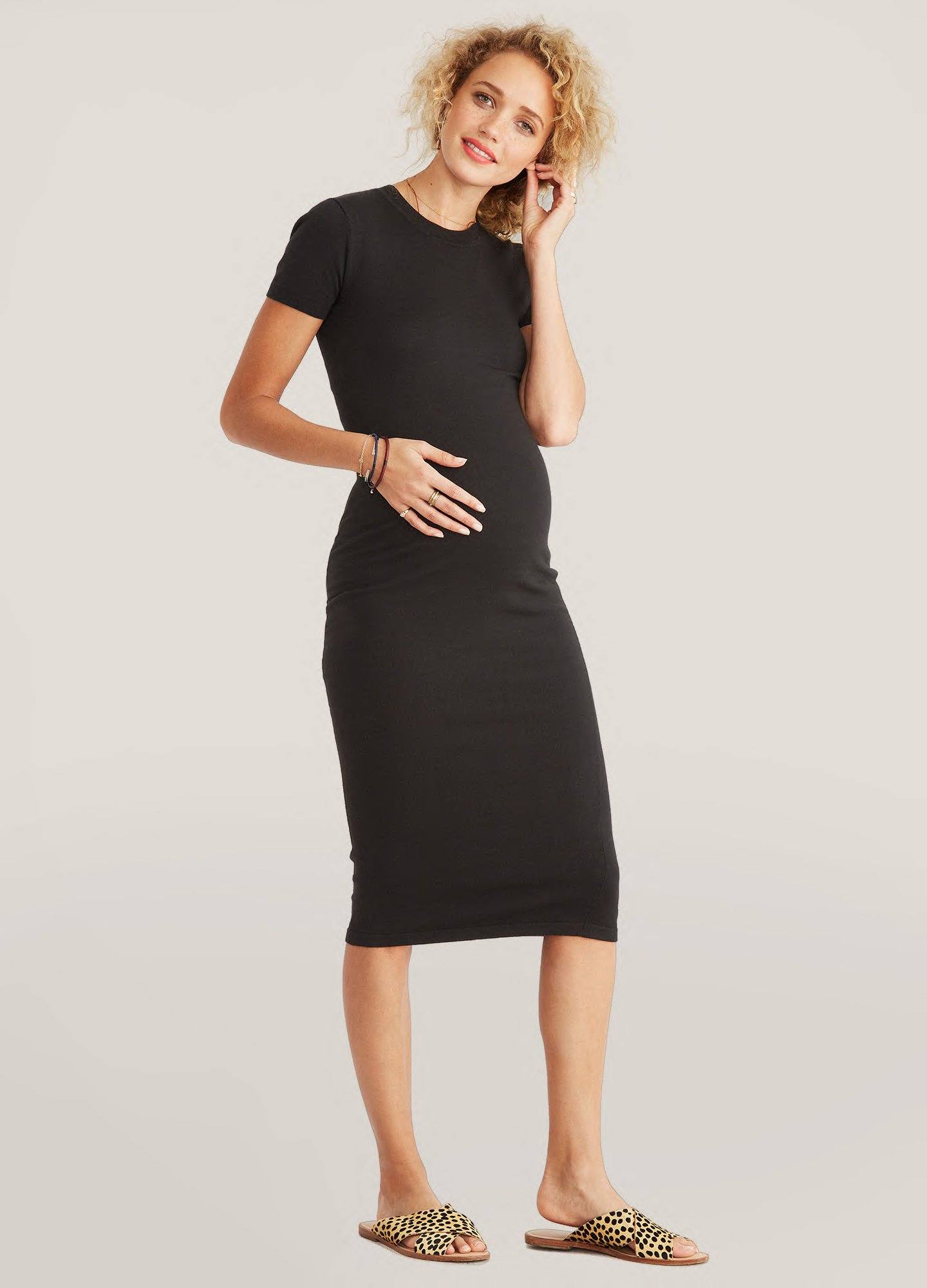 The Eliza Dress POS - Black short-sleeve maternity dress with nursing-friendly design and fitted silhouette, styled with tall black boots.
