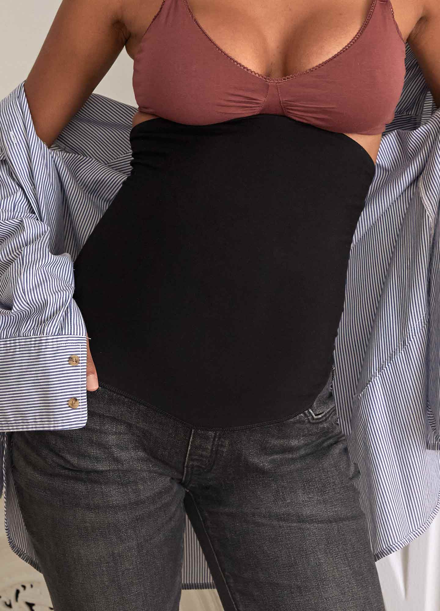 Washed black maternity jeans with over-the-bump stretchy panel on pregnant model.