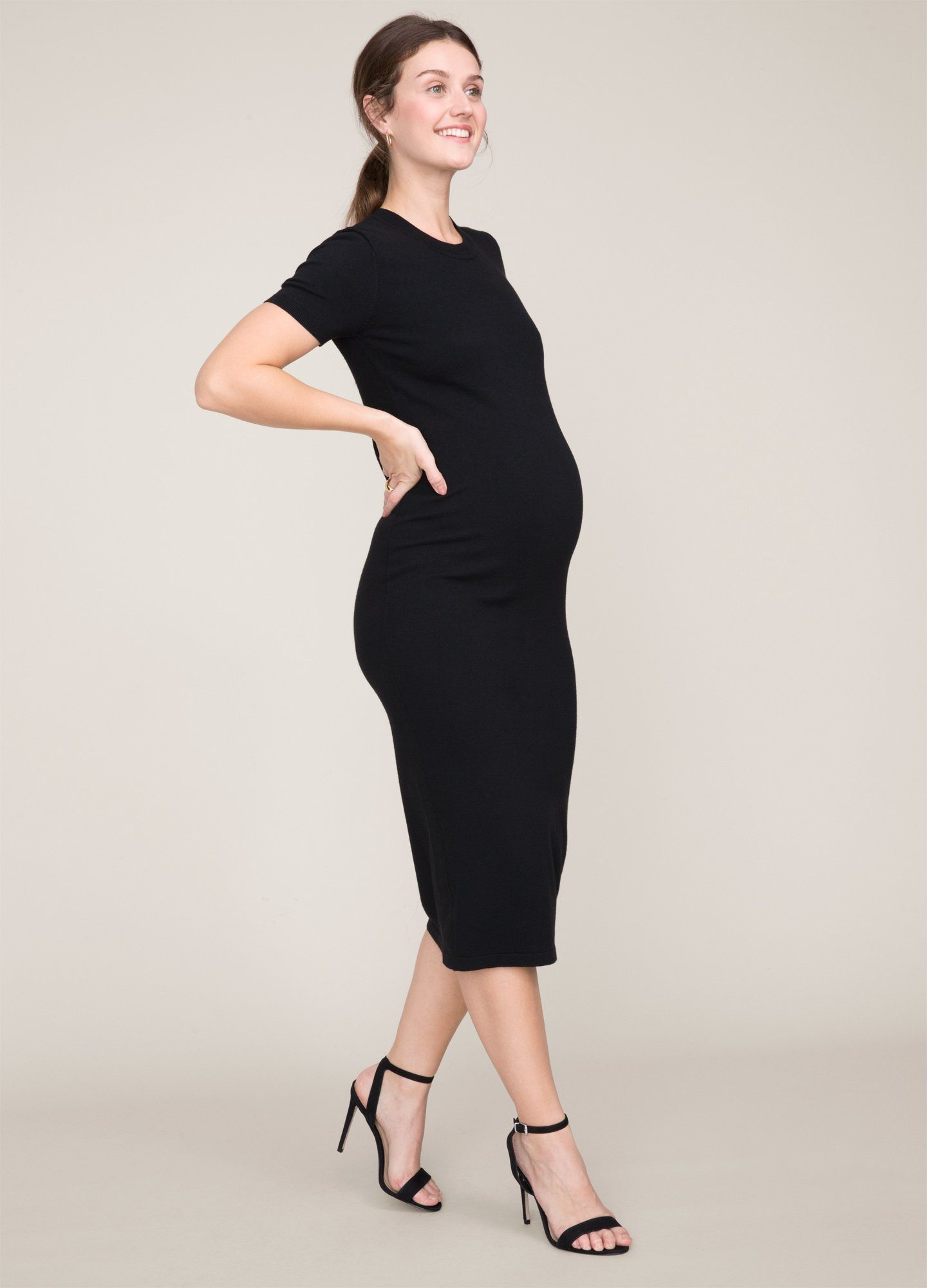 The Eliza Dress POS - Black short-sleeve maternity dress with nursing-friendly design and fitted silhouette, styled with tall black boots.