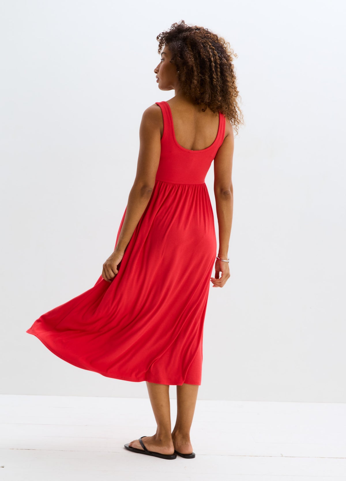 Red ribbed maternity tank dress with sleeveless scoop back and flowing midi skirt.