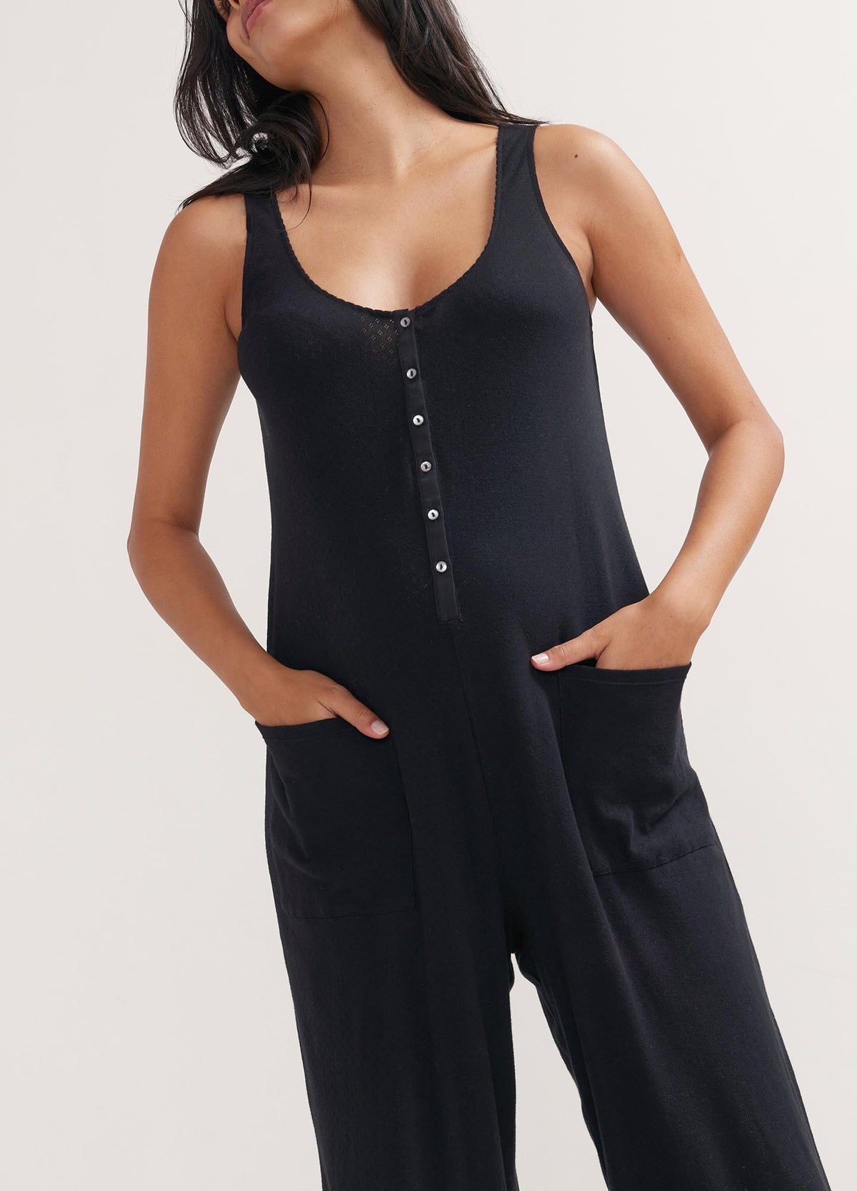 The 24/7 Feeding Jumpsuit - Black sleeveless maternity jumpsuit with button-front nursing access and relaxed fit for pregnancy and postpartum comfort.