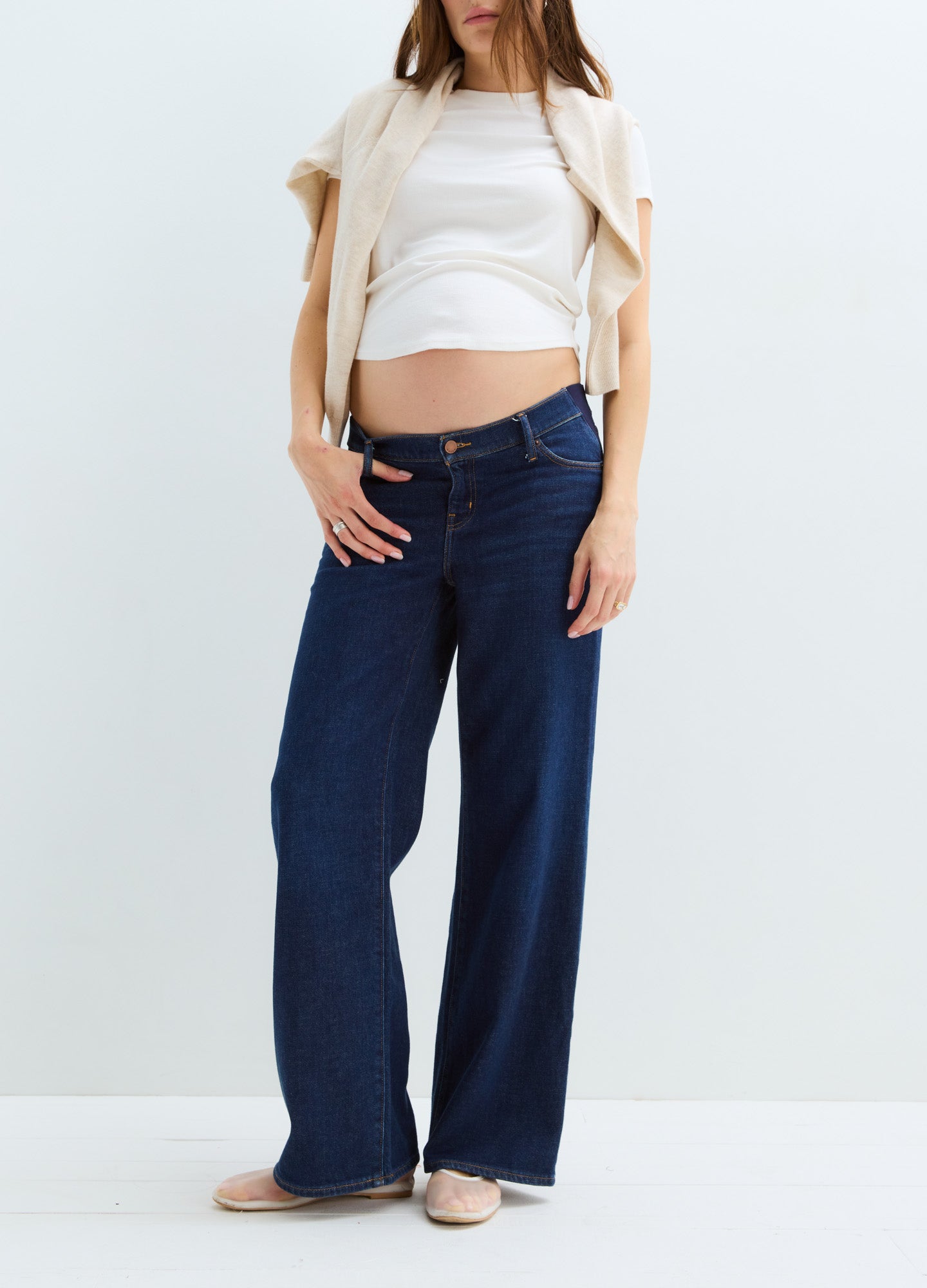 Dark blue wide-leg maternity jeans with a relaxed fit and adjustable waist, worn by a pregnant woman.