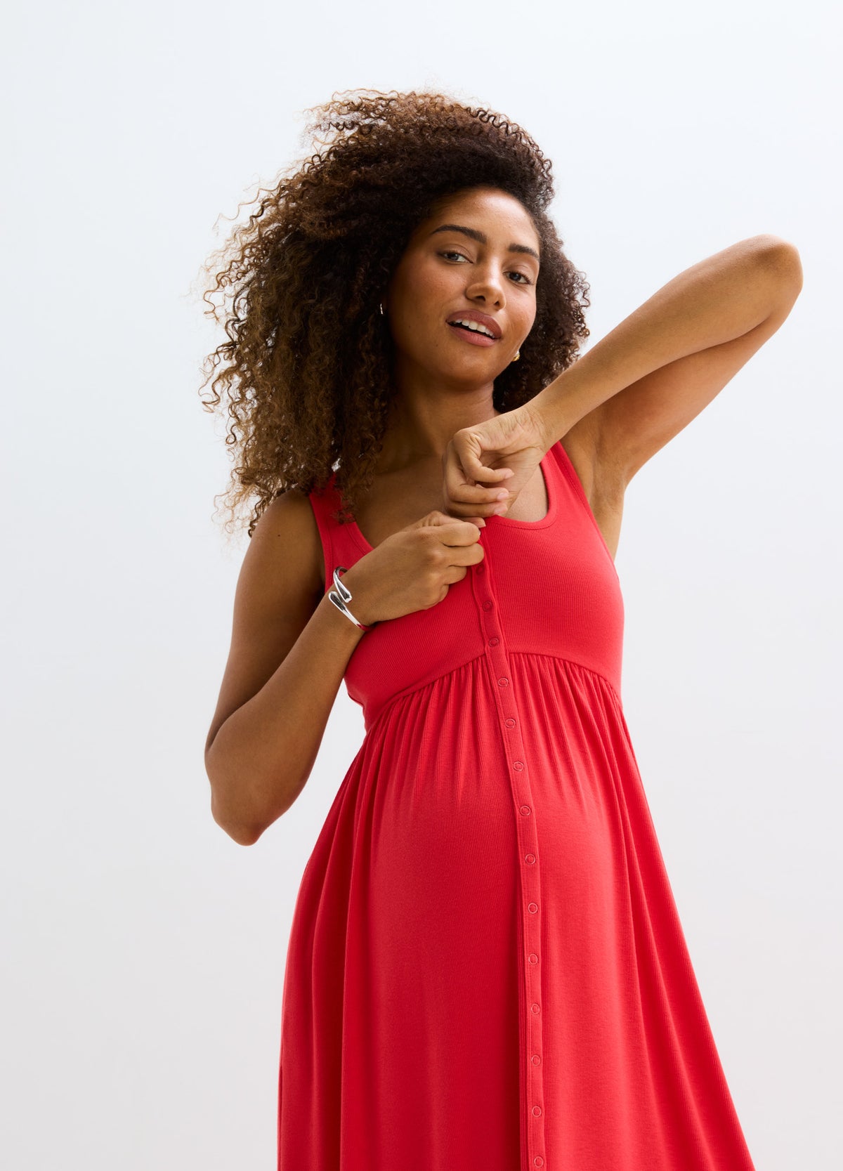 Red ribbed tank dress with front nursing access, fitted at bust and flowing over pregnant belly.