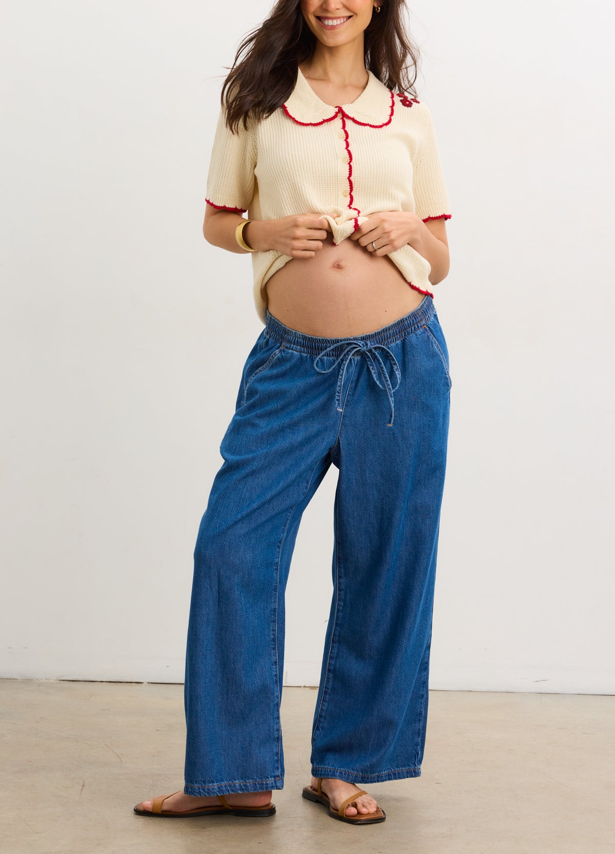 Blue wide-leg denim maternity pants with an adjustable drawstring waist and relaxed fit.