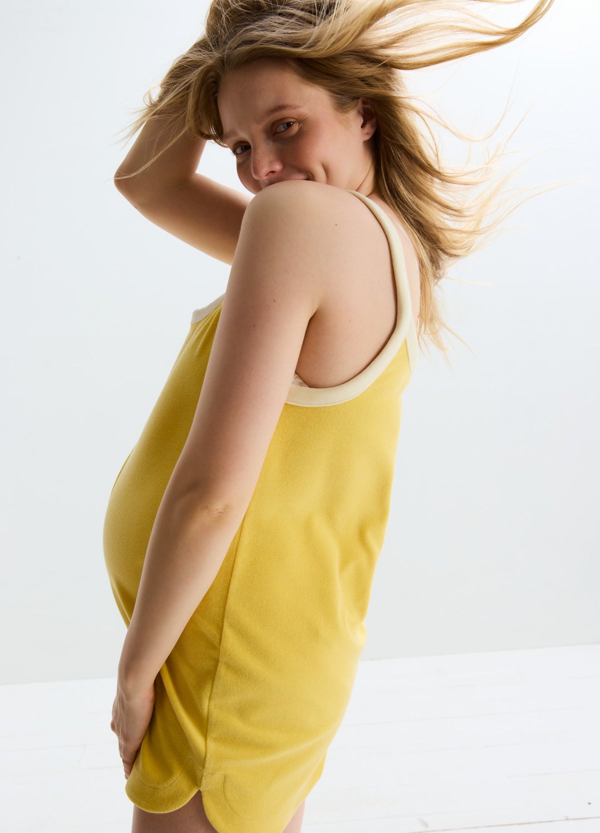 Yellow sleeveless maternity romper with beige trim and relaxed fit tailored for pregnancy.