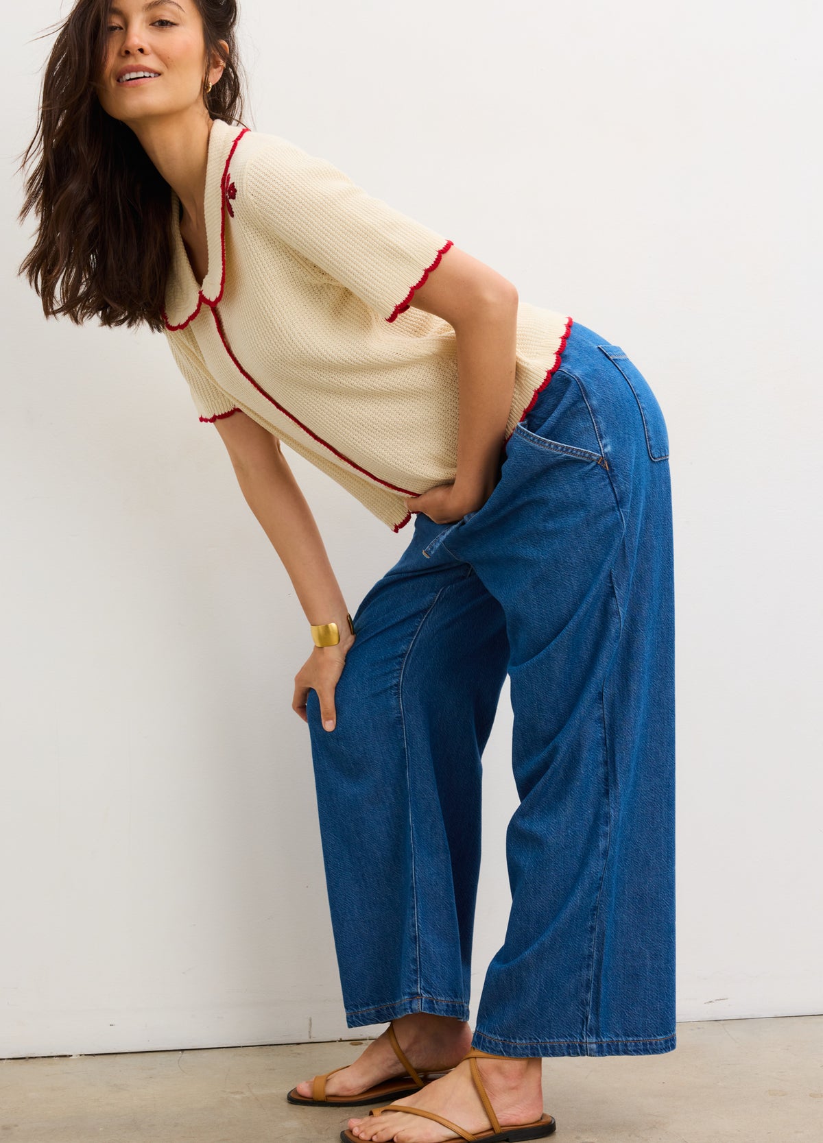 Blue wide-leg maternity denim pants with high waist, paired with cream short-sleeve top with red trim.