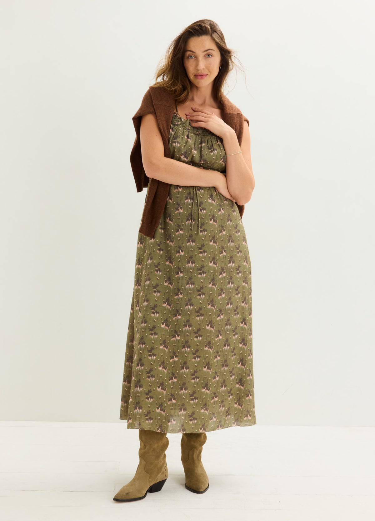 Olive green maternity dress with a delicate floral pattern, short sleeves, and a flowing midi length.