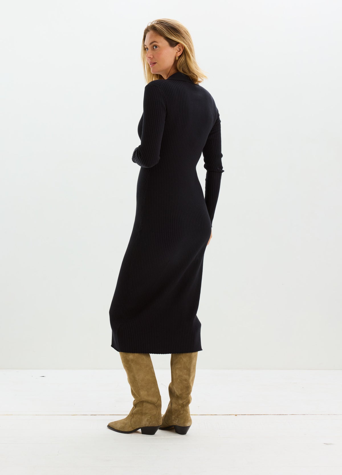Black long-sleeve midi sweater dress in stretchy knit fabric, styled for maternity with a fitted silhouette, paired with tan
