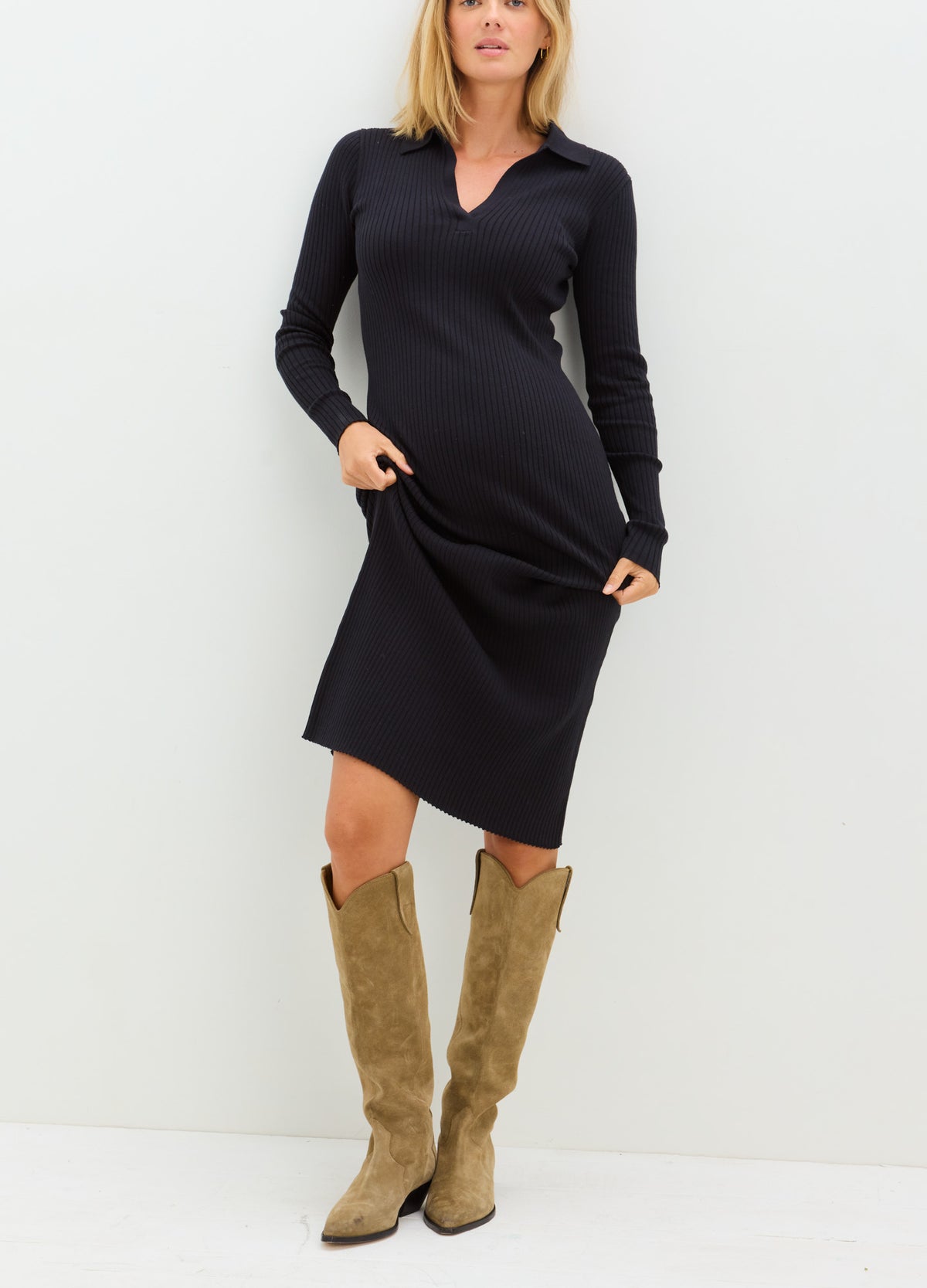 Black long-sleeve maternity sweater dress with V-neck, knee-length, worn with tan suede knee-high boots.