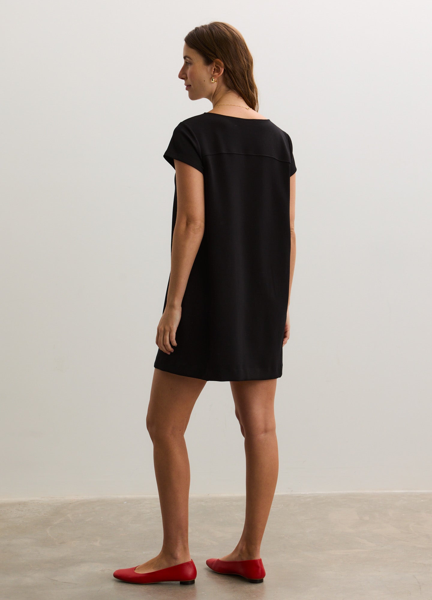 Black short-sleeve maternity dress with a loose, straight silhouette and a round neckline.