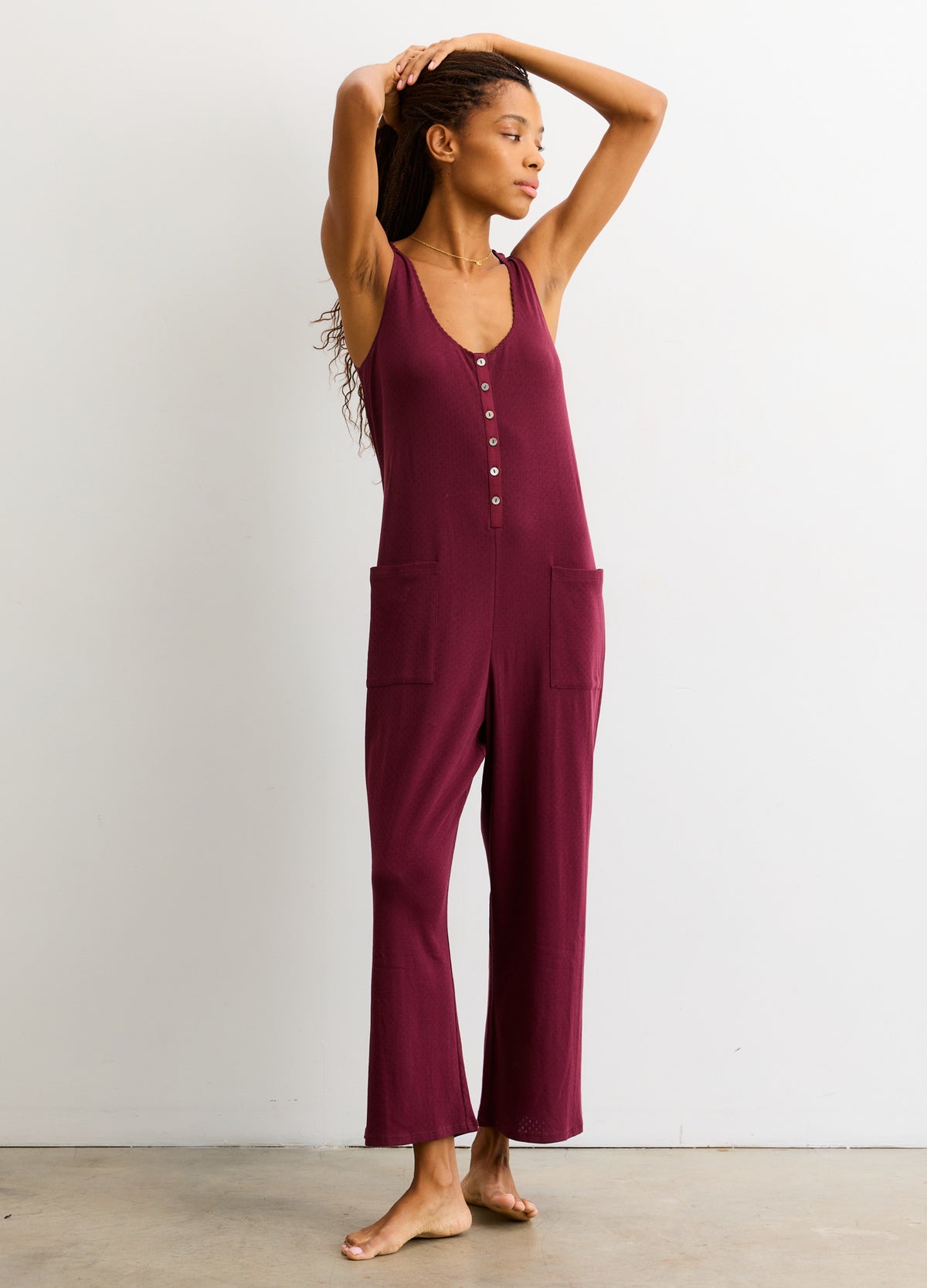 Sleeveless deep mauve maternity jumpsuit with front buttons and wide leg pockets, soft knit.