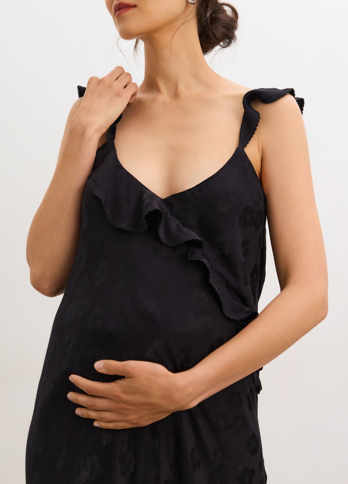 Black jacquard bias-cut slip dress with ruffled straps and maternity fit.