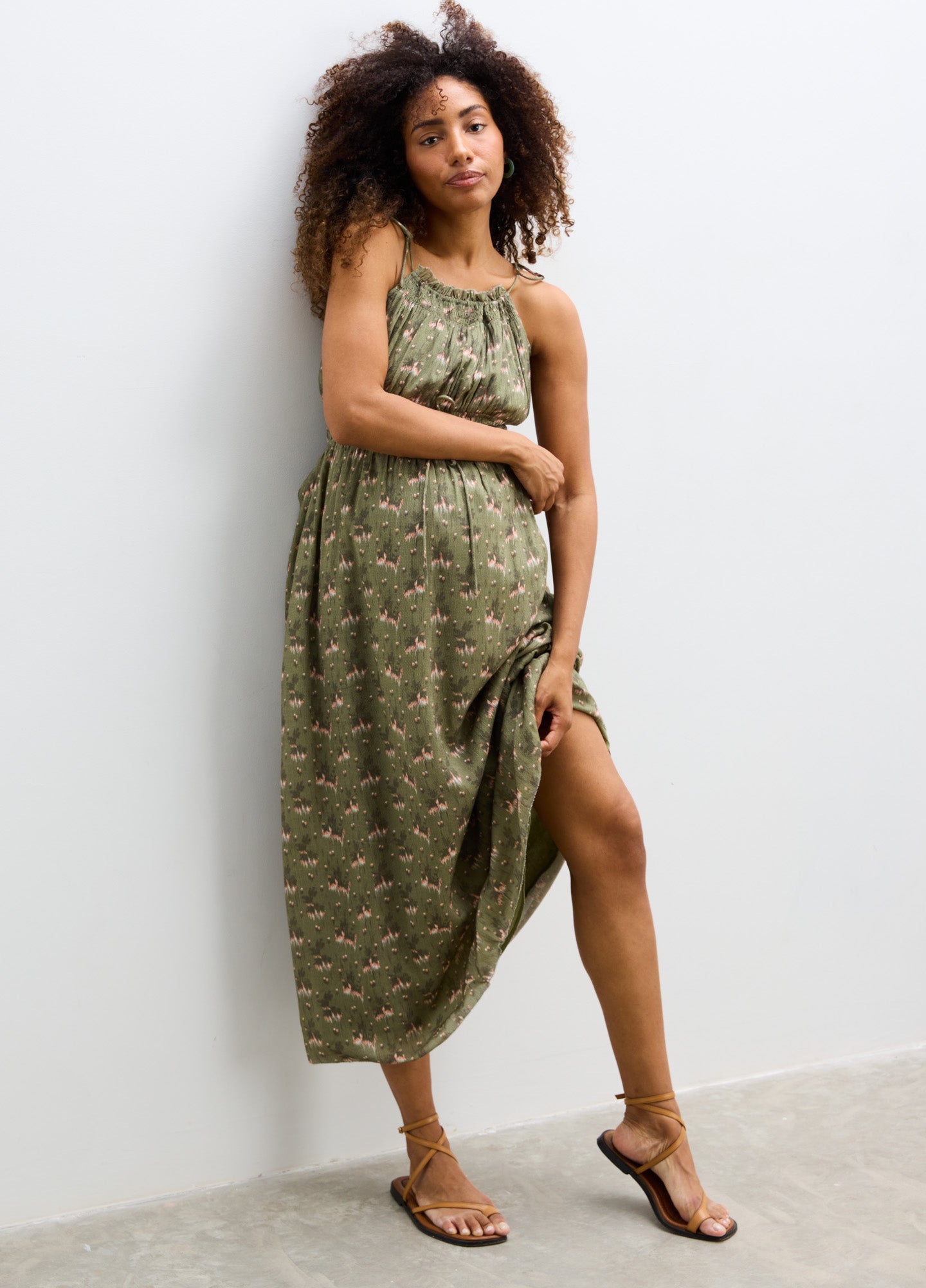 Olive green sleeveless maternity dress with delicate floral print, scoop neckline, and relaxed fit.