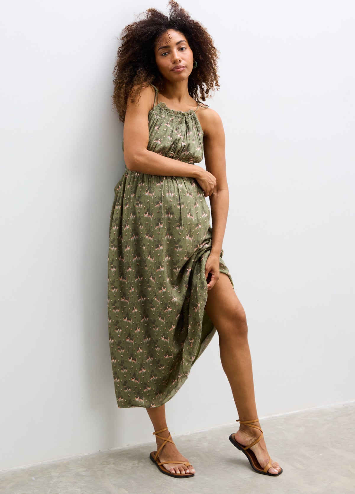 Olive green sleeveless maternity dress with delicate floral print, scoop neckline, and relaxed fit.