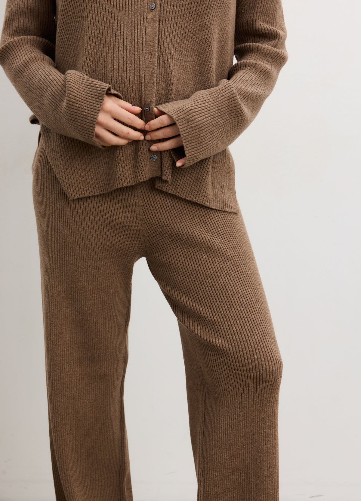 Brown ribbed knit maternity pants with a relaxed fit and stretchy waistband designed for pregnancy comfort.