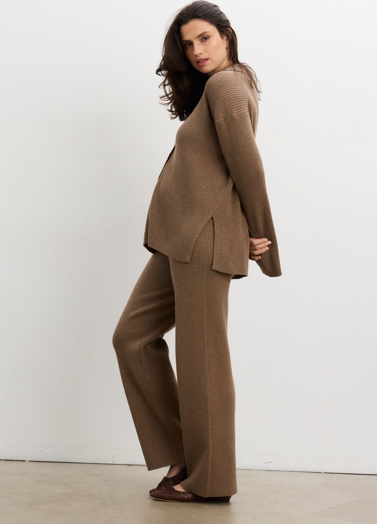 Pregnant model wearing doe melange ribbed knit buttondown polo and matching maternity pants in relaxed fit.