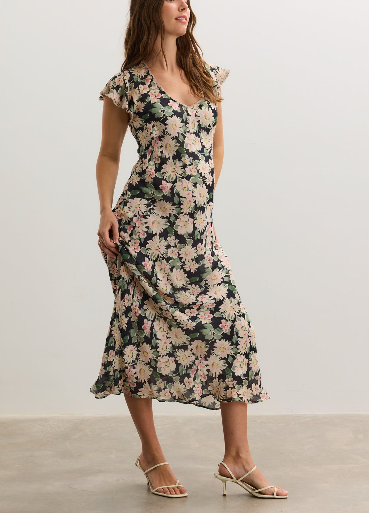 Floral midi maternity dress with short flutter sleeves and fitted empire waist in soft fabric.