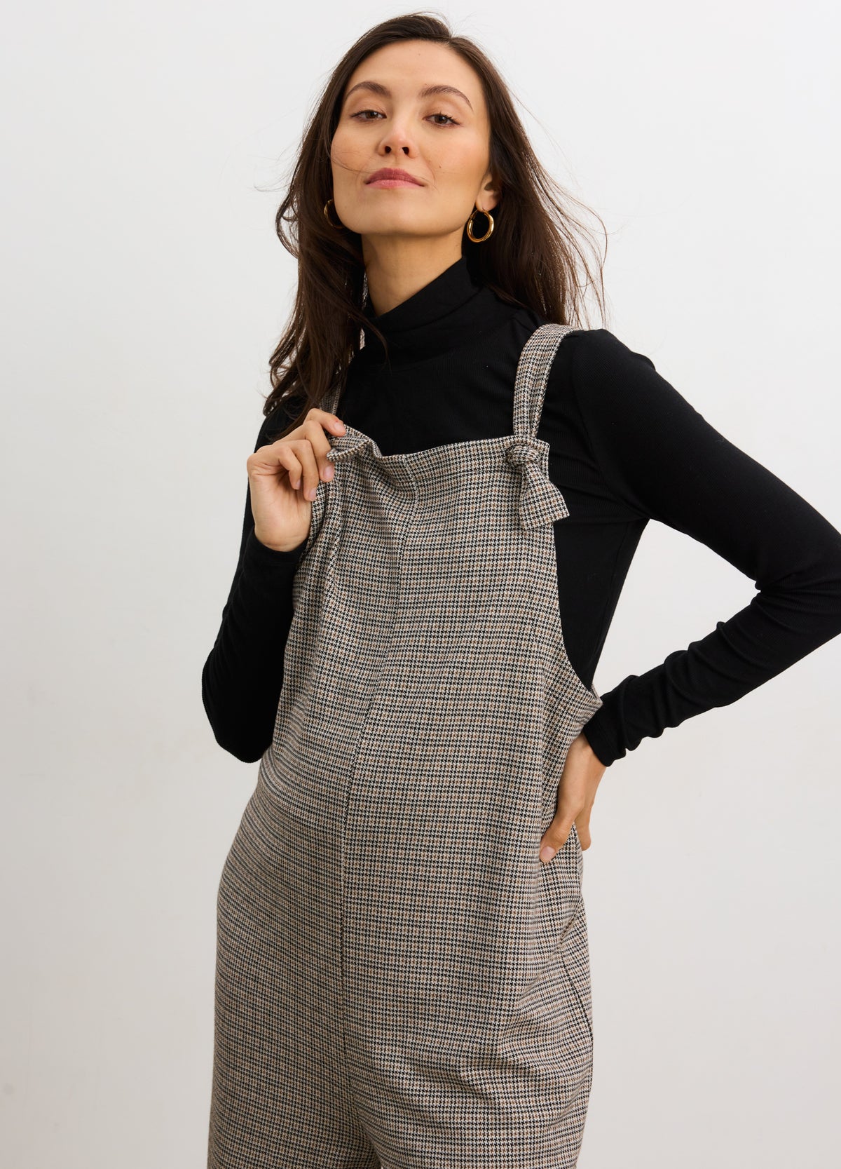 Maternity soft stretch onesie with mini houndstooth pattern, worn over black turtleneck, designed for pregnant comfort.