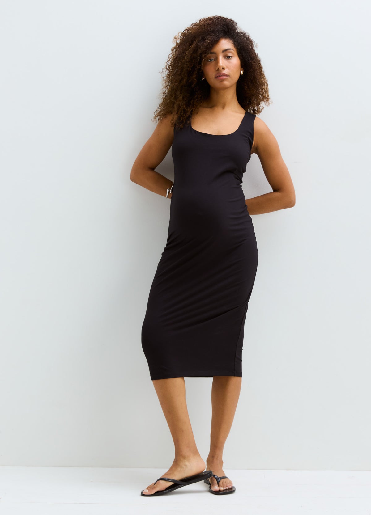 Sleeveless black maternity bodycon tank dress with scoop neckline, midi length, stretchy fabric.